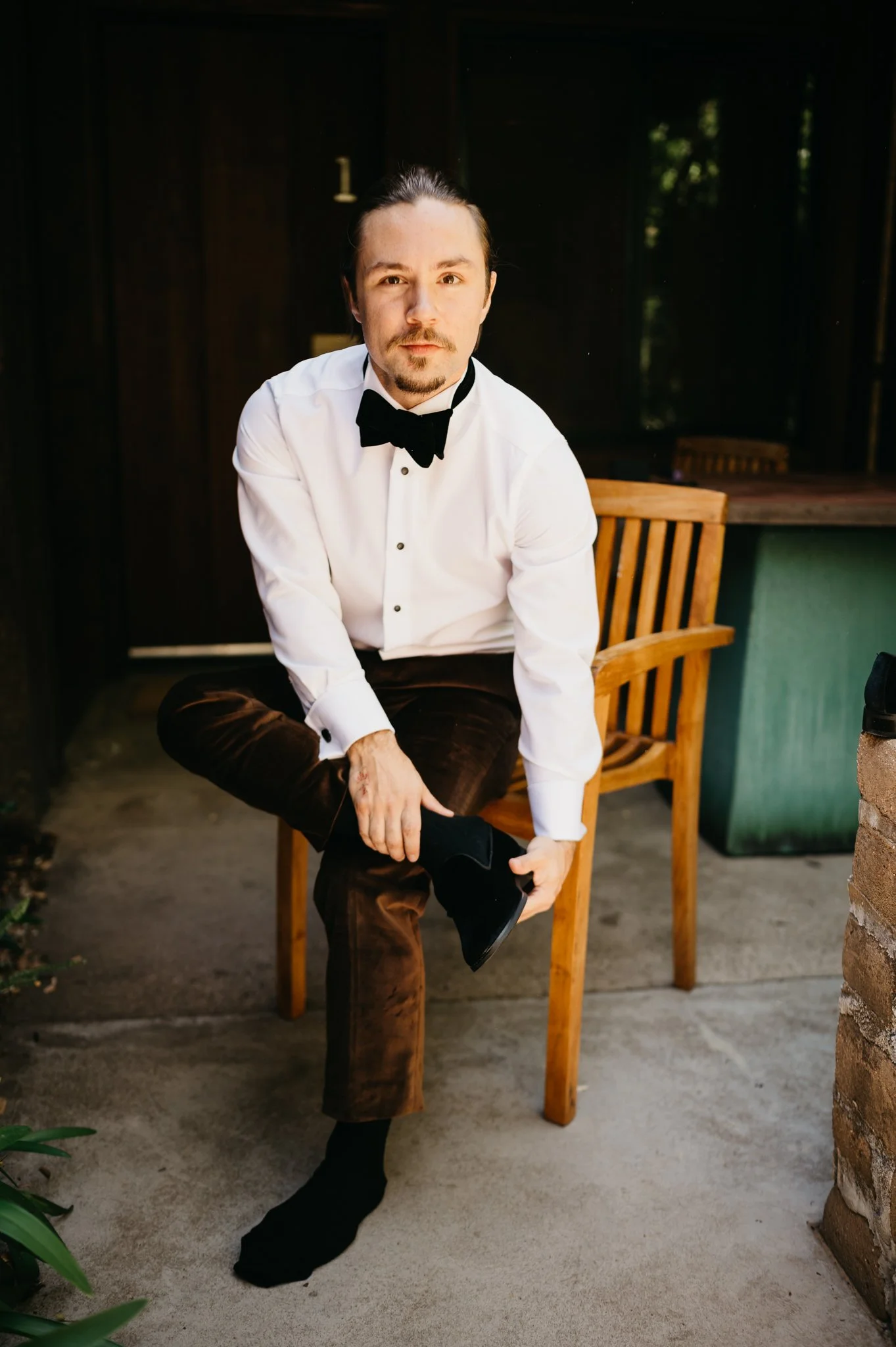 groom putting on dress shoes at Glen Oaks Big Sur