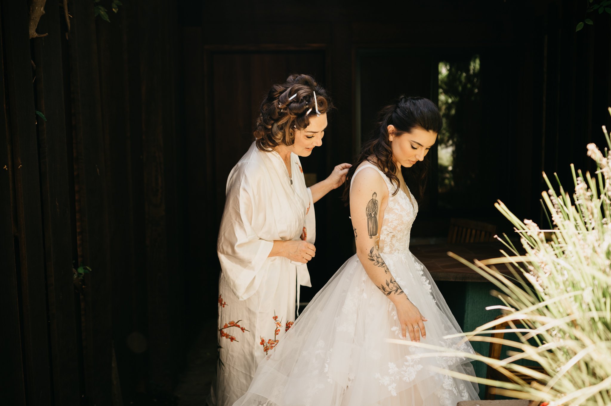bride in wedding dress and maid of honor in robe getting ready for ceremony Big Sur wedding
