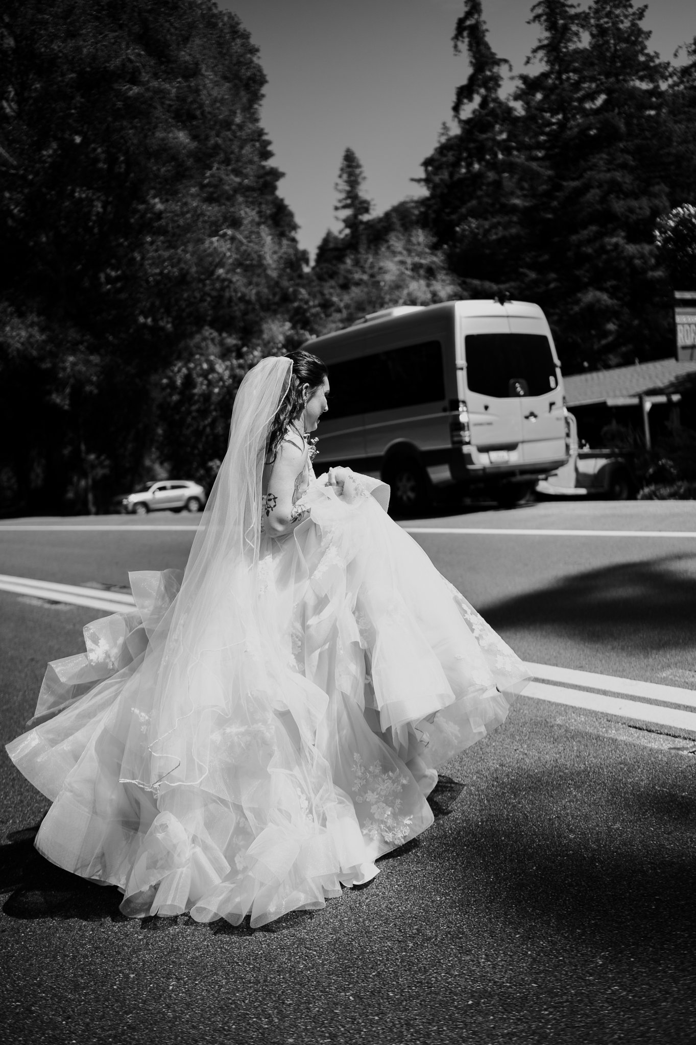 Black and white of bride in wedding dress walking out to Highway 1 Big Sur before Ceremony 
