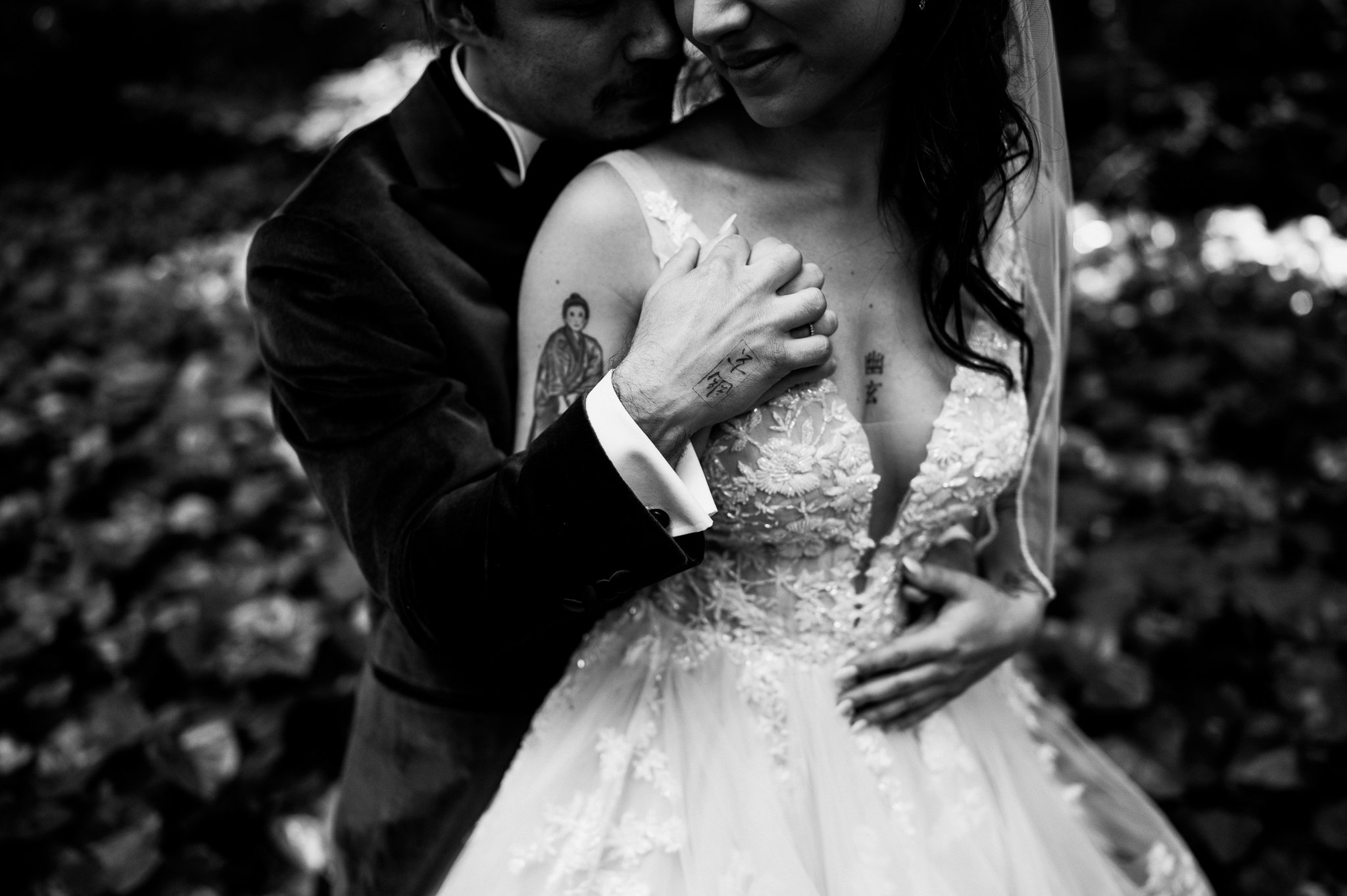black and white of bride and grooms upper body he is behind her with his arms around her