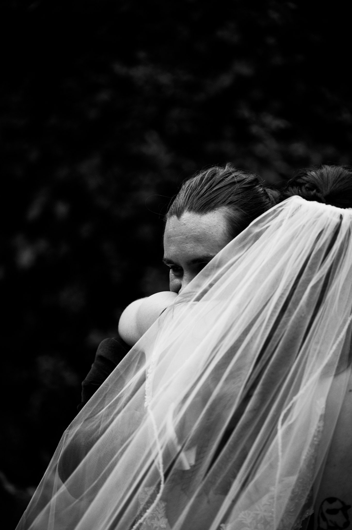 Black and white of bride and groom hugging