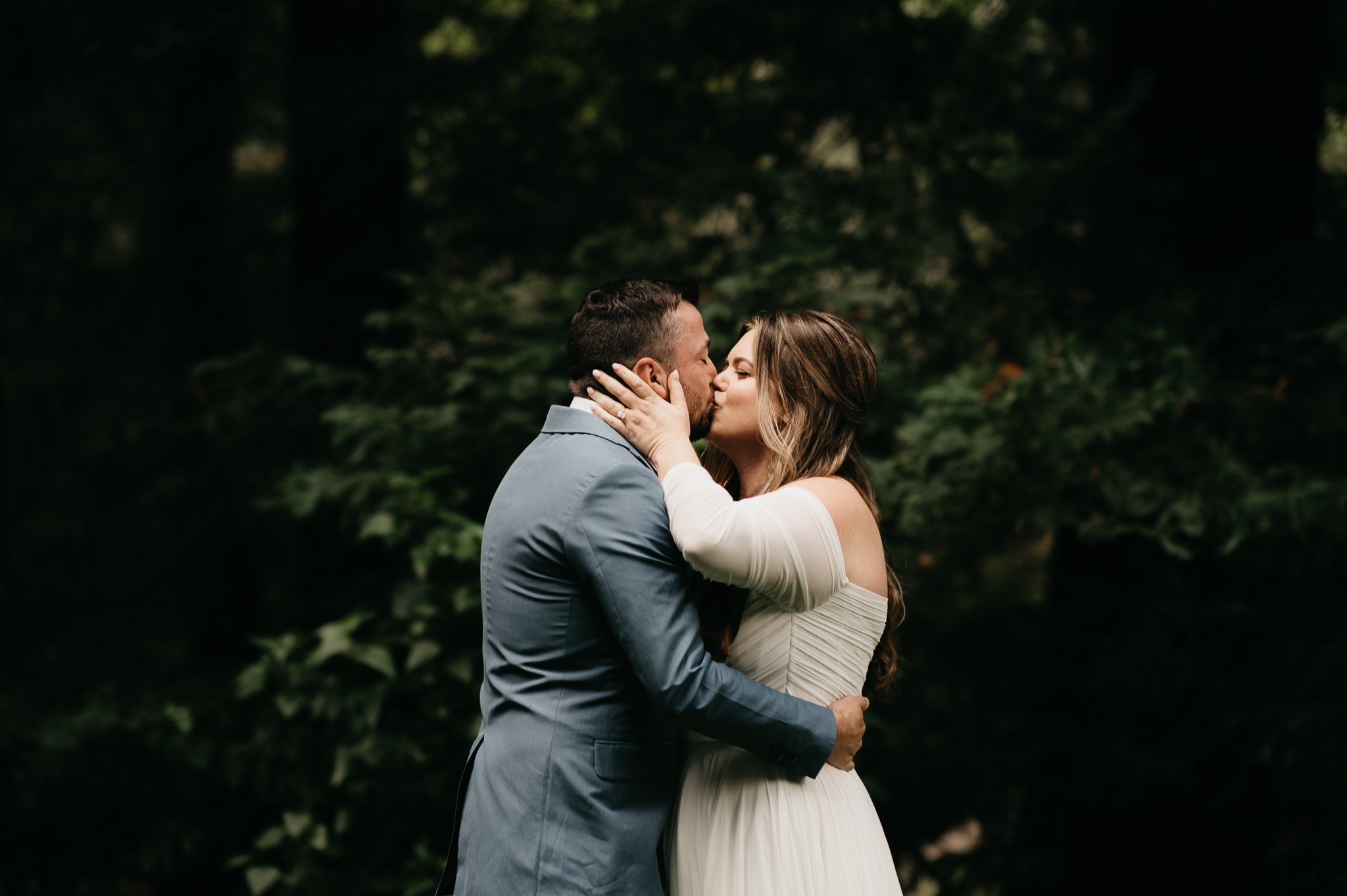 Bride and groom and Glen Oaks Big Sur in forest kissing at there first look