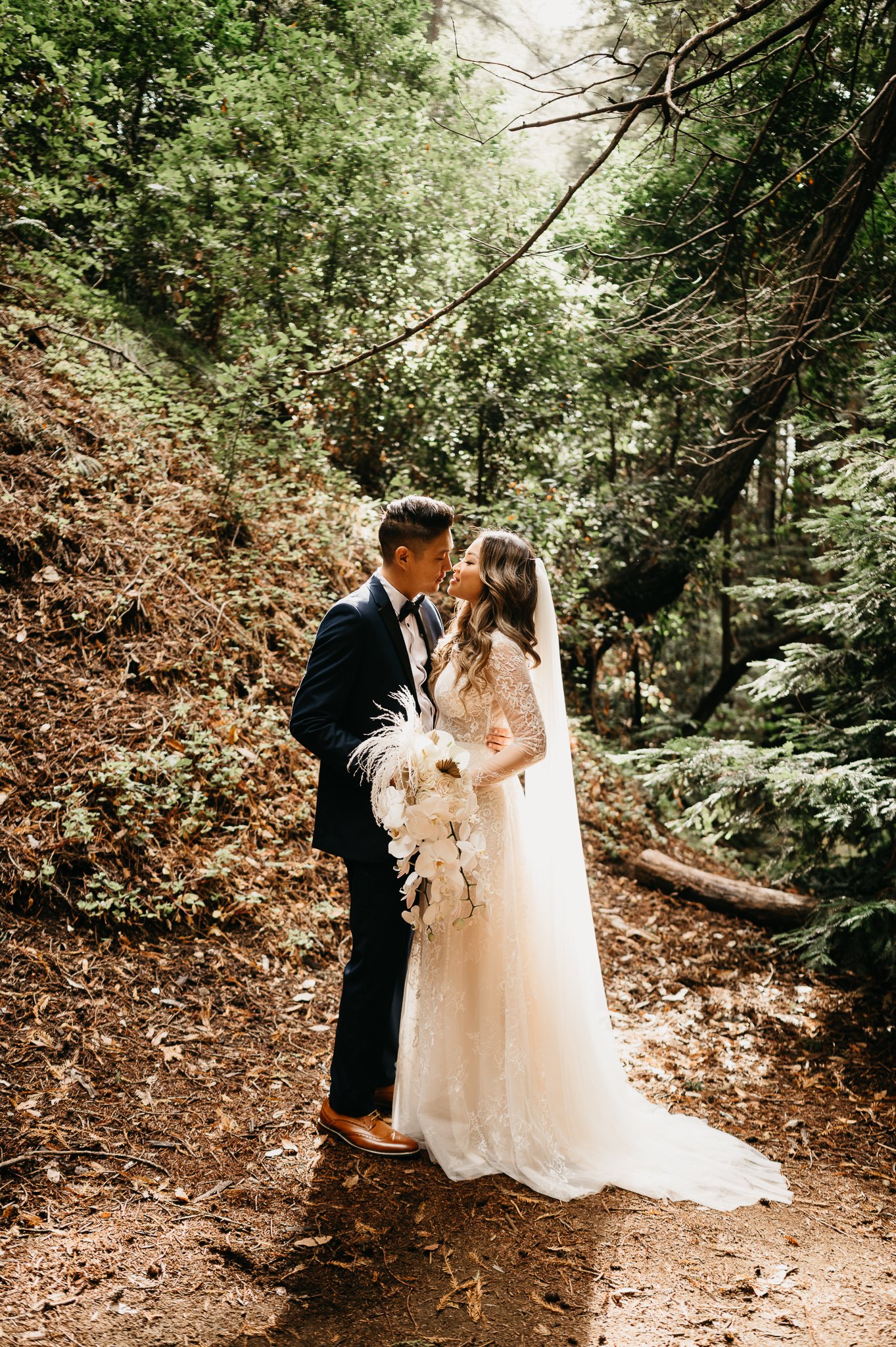 Bride and groom in the Ventana forest Big Sur California in wedding attire kissing