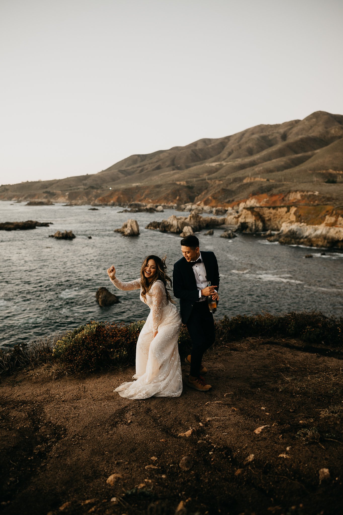 Bride and groom dancing on cliff in Big Sur after ceremony 