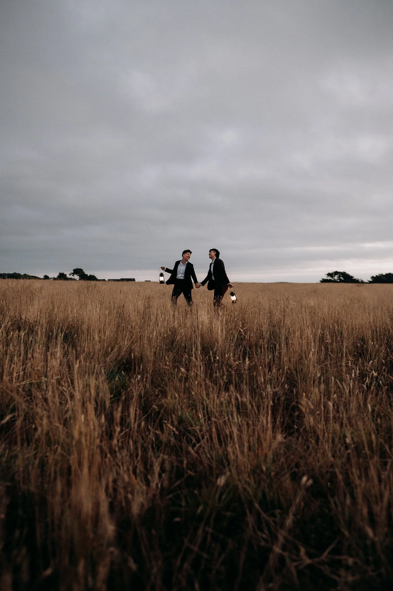 LGBTQ elopement couple walking through tall grass on the coast of Mendocino