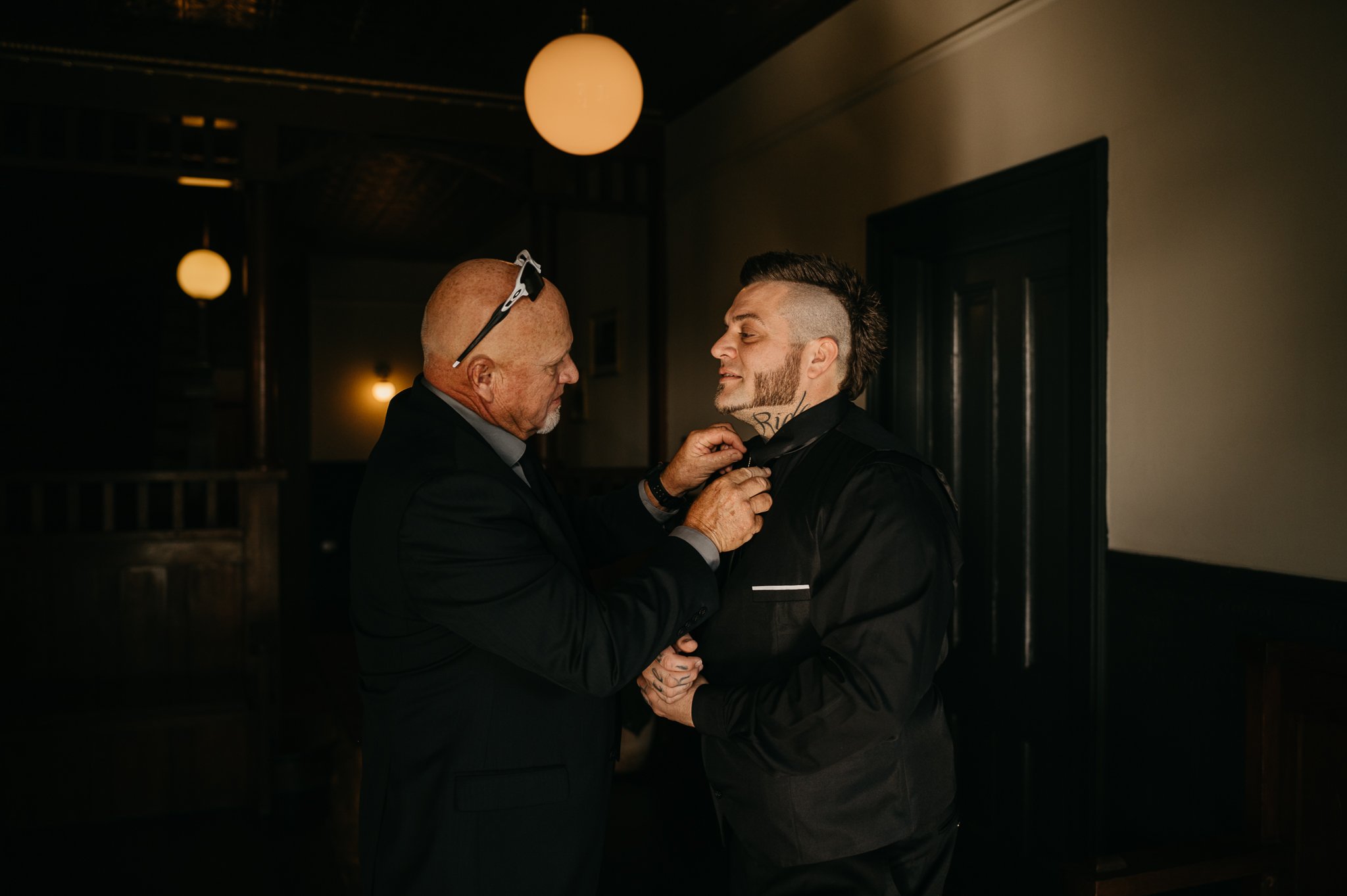 Groom getting a little help from his father fixing his tie from before wedding ceremony in Mendocino, California