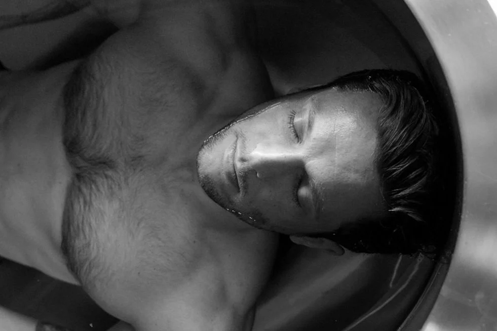A man laying in an ice bath, relaxing