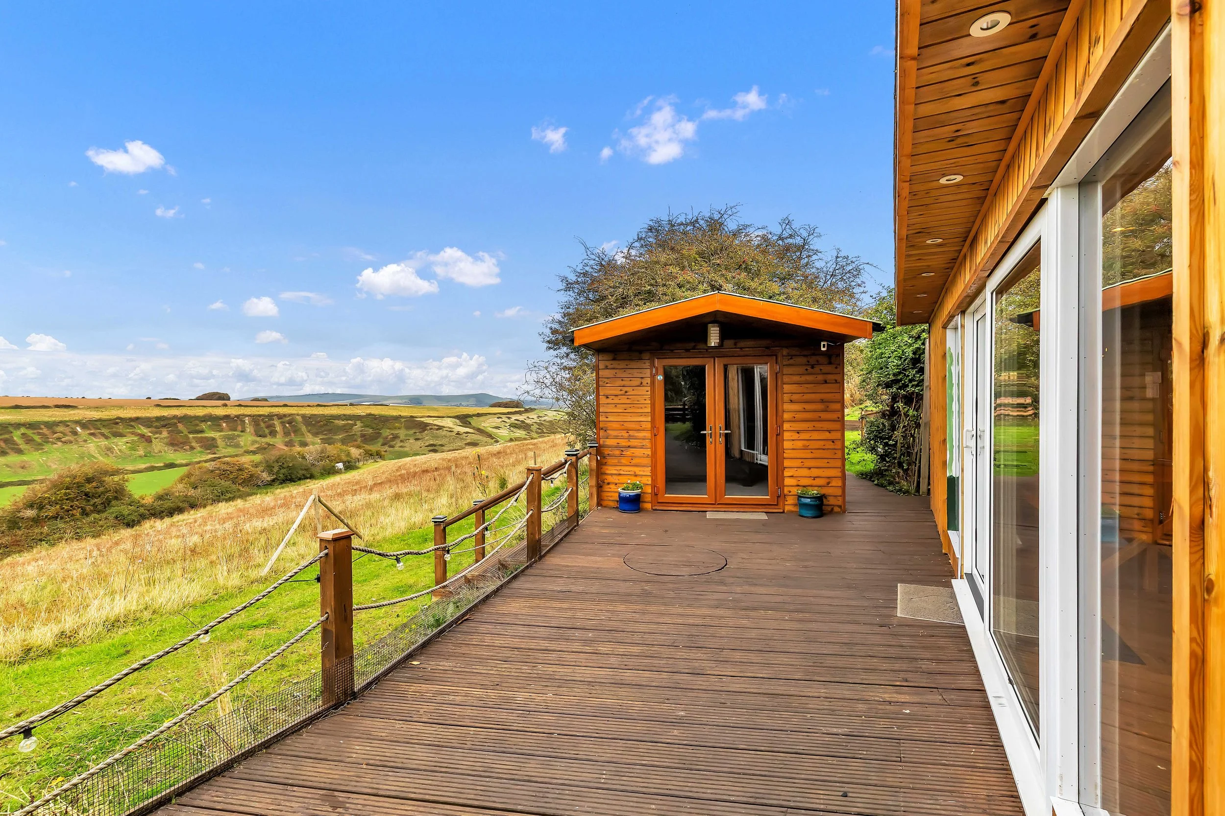 View of the cabin from the outside against sweeping views of the South Downs