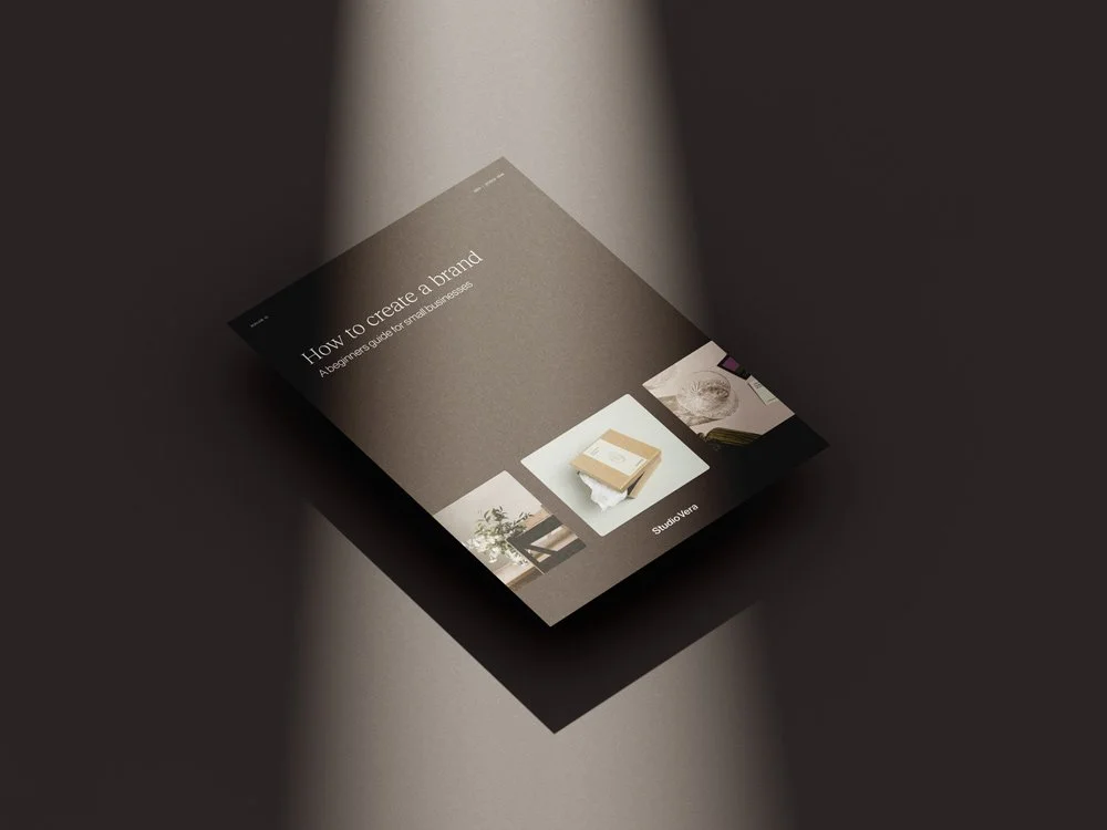 Brochure titled 'How to Create a Brand: A Beginner's Guide to Smart Businesses' displayed on brown surface.