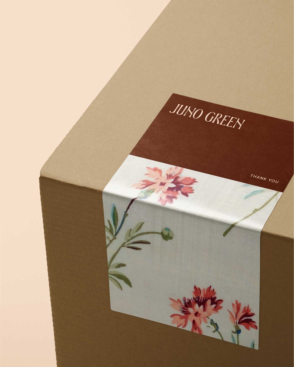 high end packaging with a floral-patterned paper sleeve and a label that says 'Juno Green'