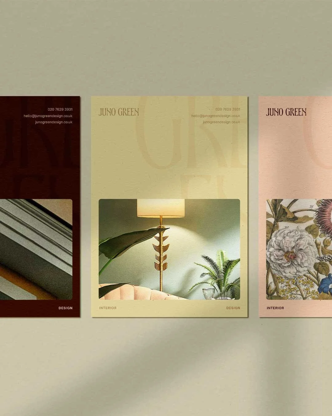 Three interior design posters on a wall, each with a different color background and images of home decor. The middle poster features a lamp and green plants.
