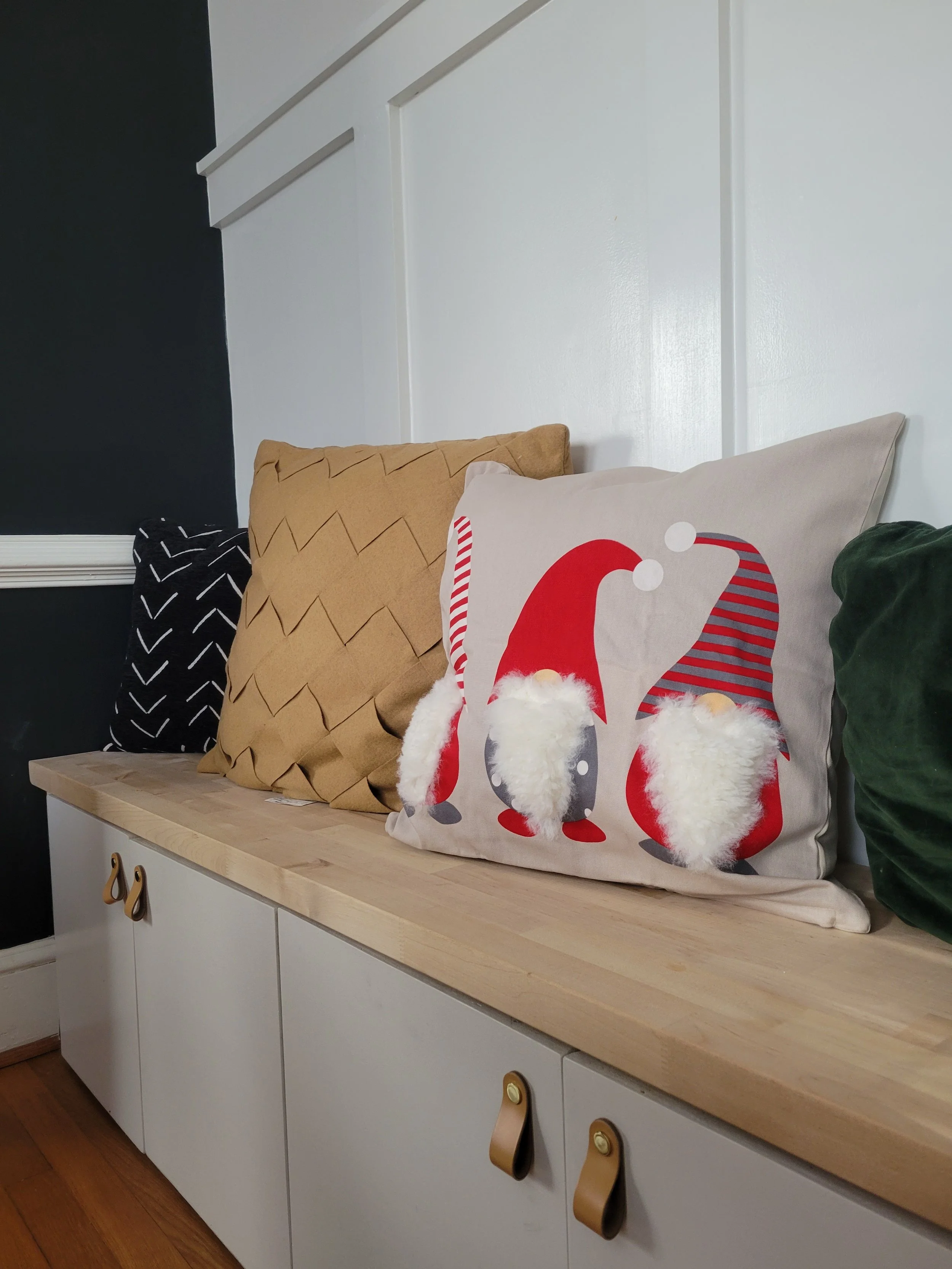 Custom built 8 ft dining bench with cabinet door storage and a board and baton feature wall.