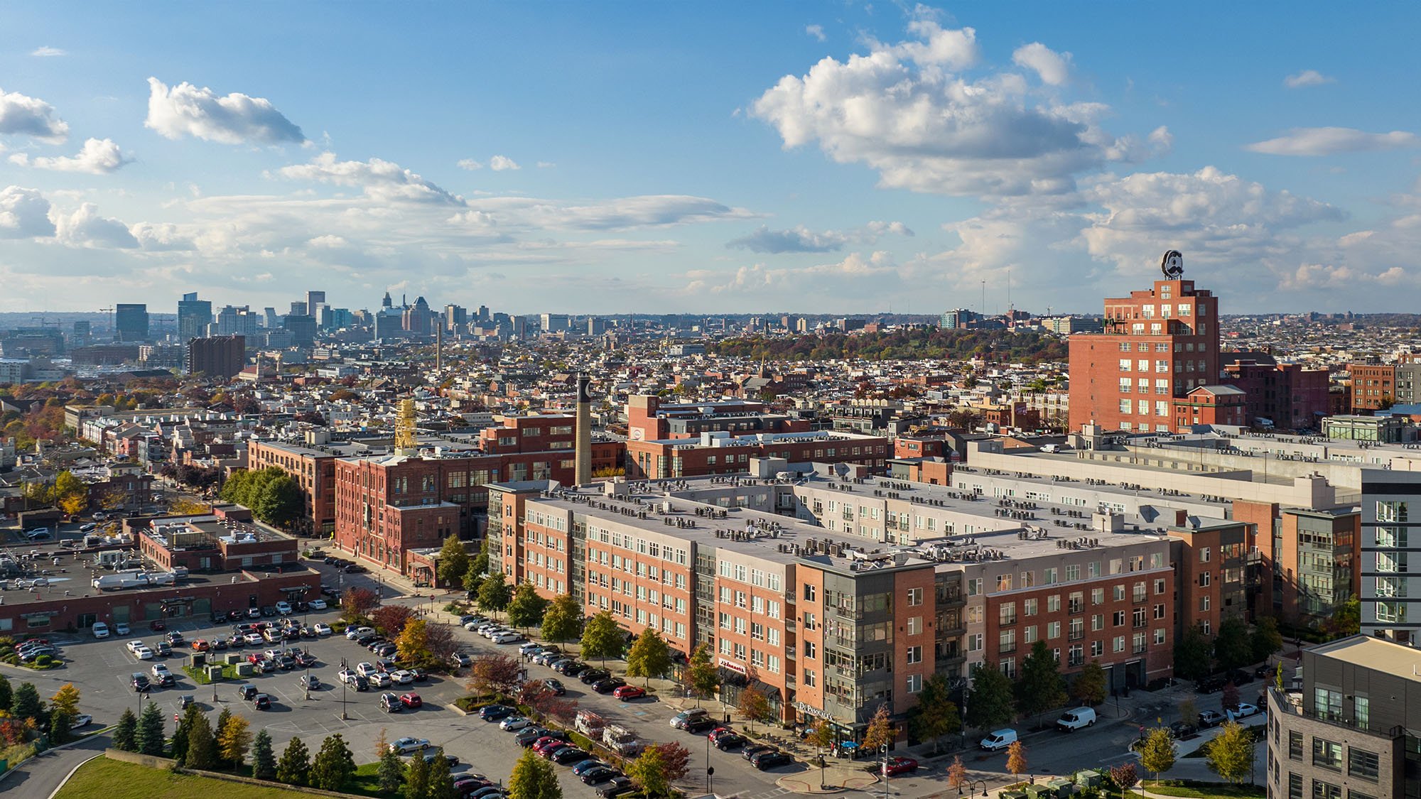 Aerial view of The Porter luxury apartments in Brewers Hills with Downtown Baltimore, MD in background.