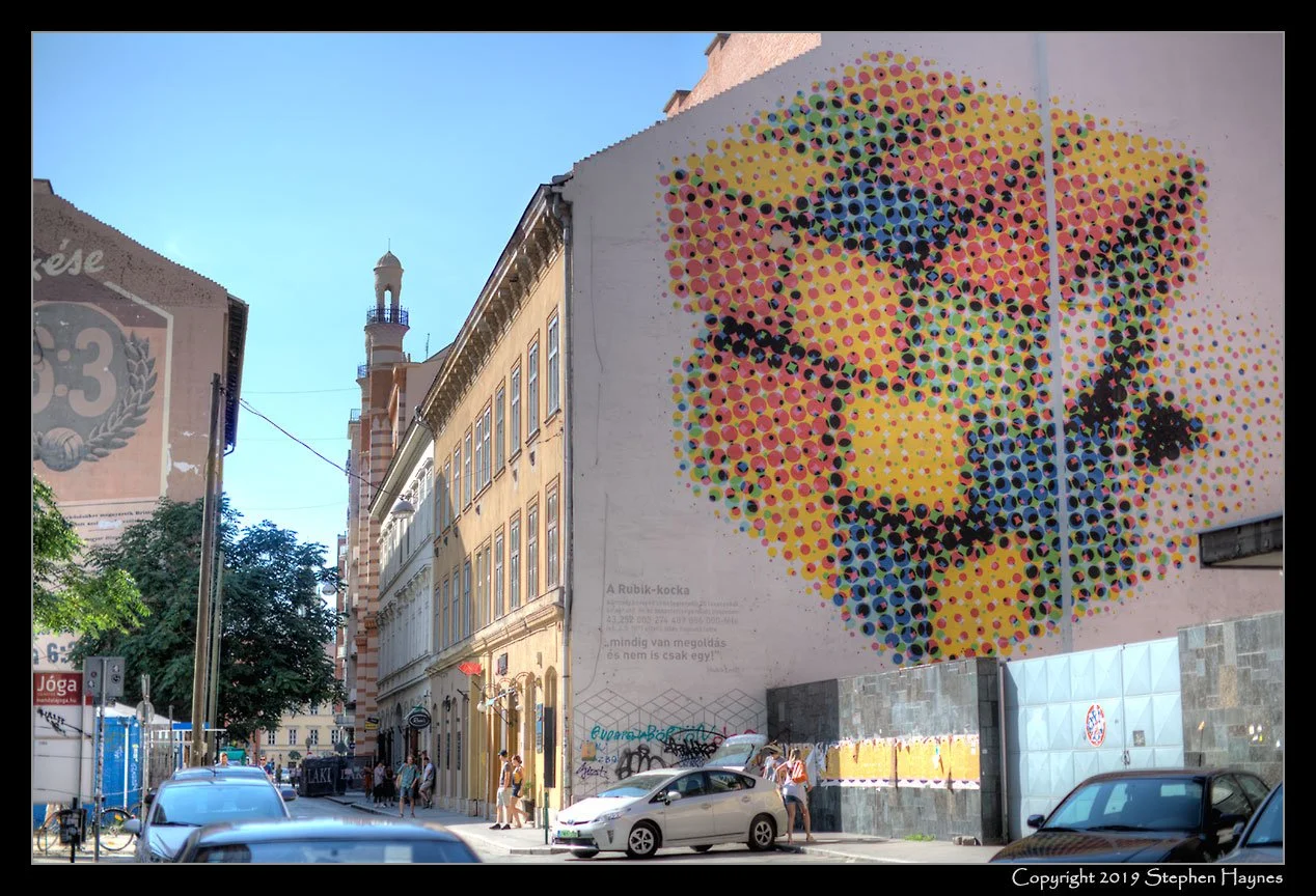 Budapest - Rubik's Cube -- 
Rubik's Cube was invented in Budapest in 1974 by Hungarian sculptor and professor of architecture Ernö Rubik.  See https://en.wikipedia.org/wiki/Rubik%27s_Cube
