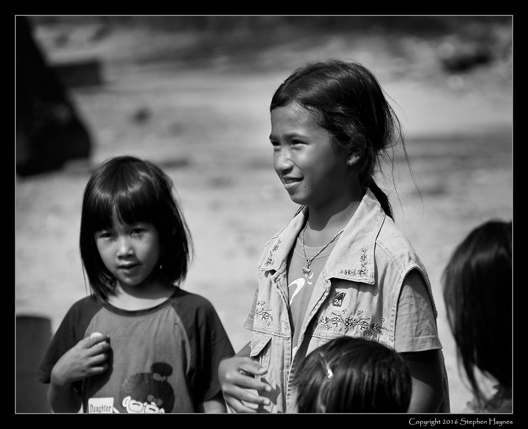 Ropang Ropov Fishing Village, On the road east from Sihanoukville, Cambodia --
The children became more comfortable and ventured near, encouraged by our guide.
(Note the "24" sticker on the taller girl's shirt, given her by one of the tour members.