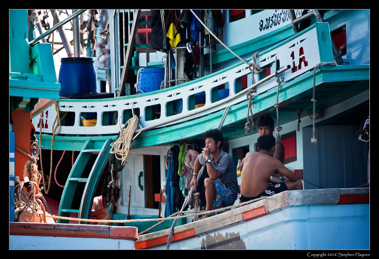 Nathon, Koh Samui, Thailand --
As our ship's tender departed from the wharf at Nathon, I was able to capture both
closeups and more distant views (next image) of the large fishing fleet and its sailors.
