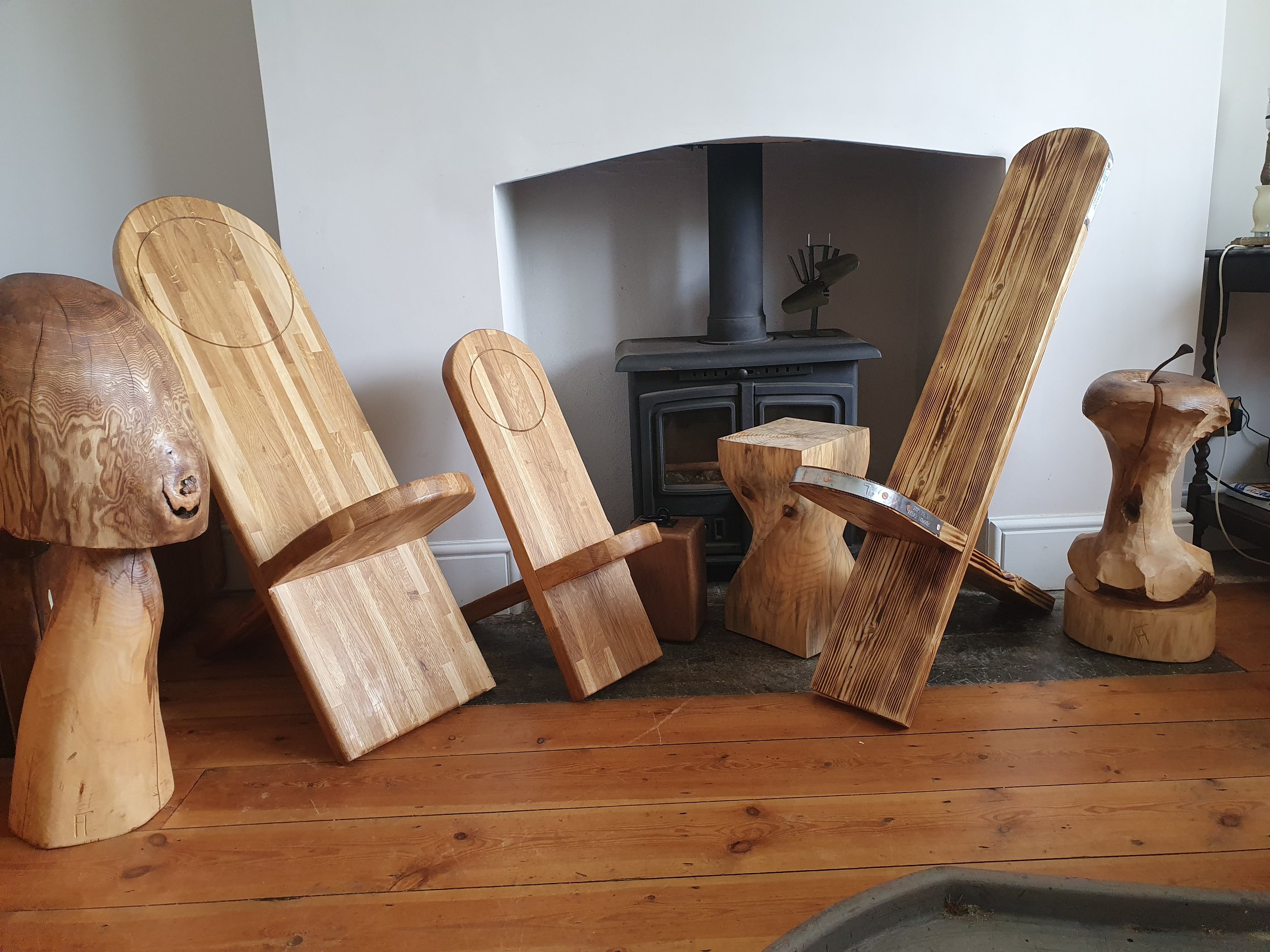 From the left, Tim's take on a Magic Mushroom carved out of Ash. Two viking seats from a reclaimed worktop. A twisted stool carved from a piece of Monkey Puzzle. A scaffold viking chair and finally a apple core carved from Ash, the pips and stem are