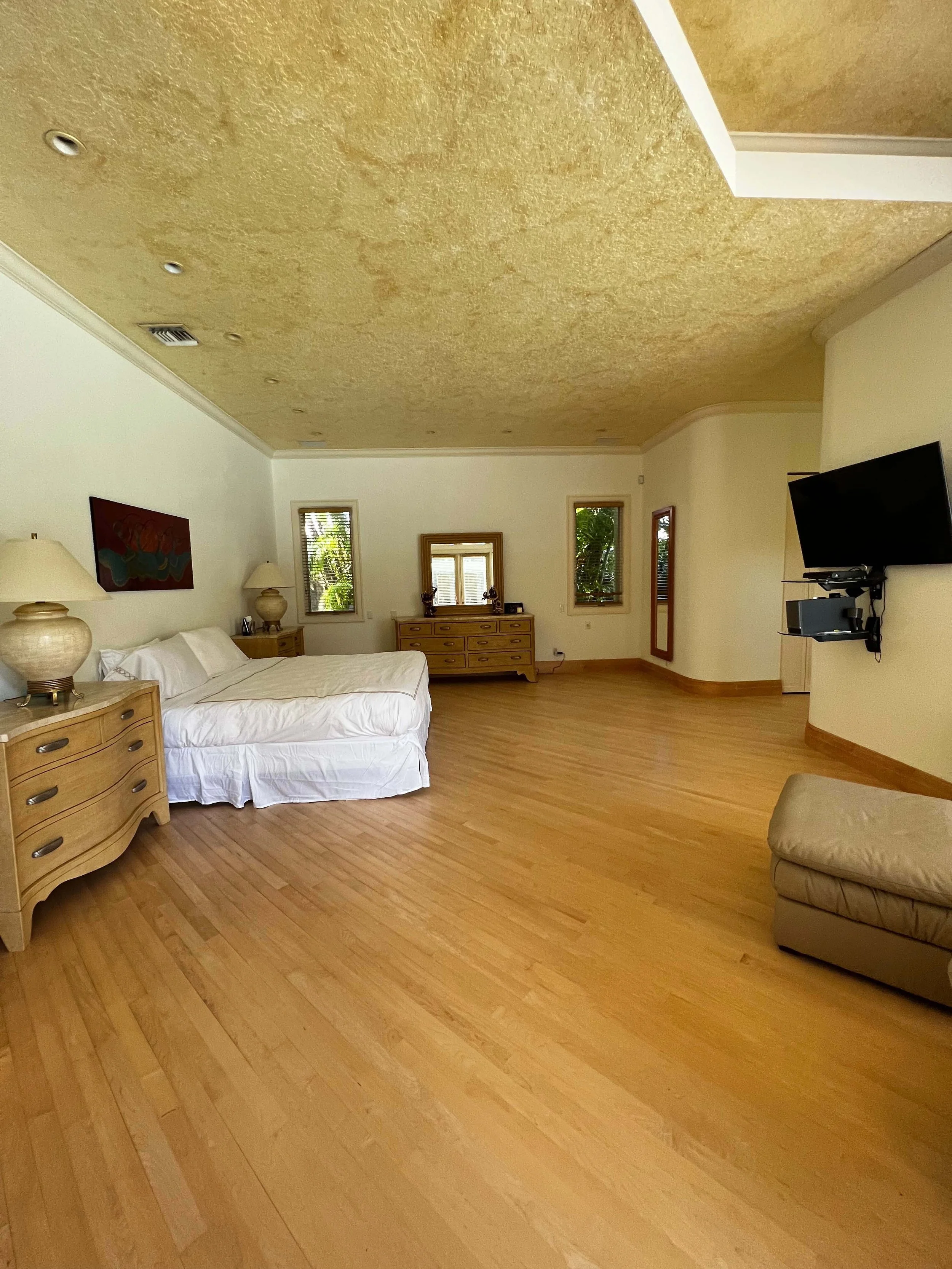 BEFORE- Yellow-stained ceiling and marooned furniture in an oversized footprint