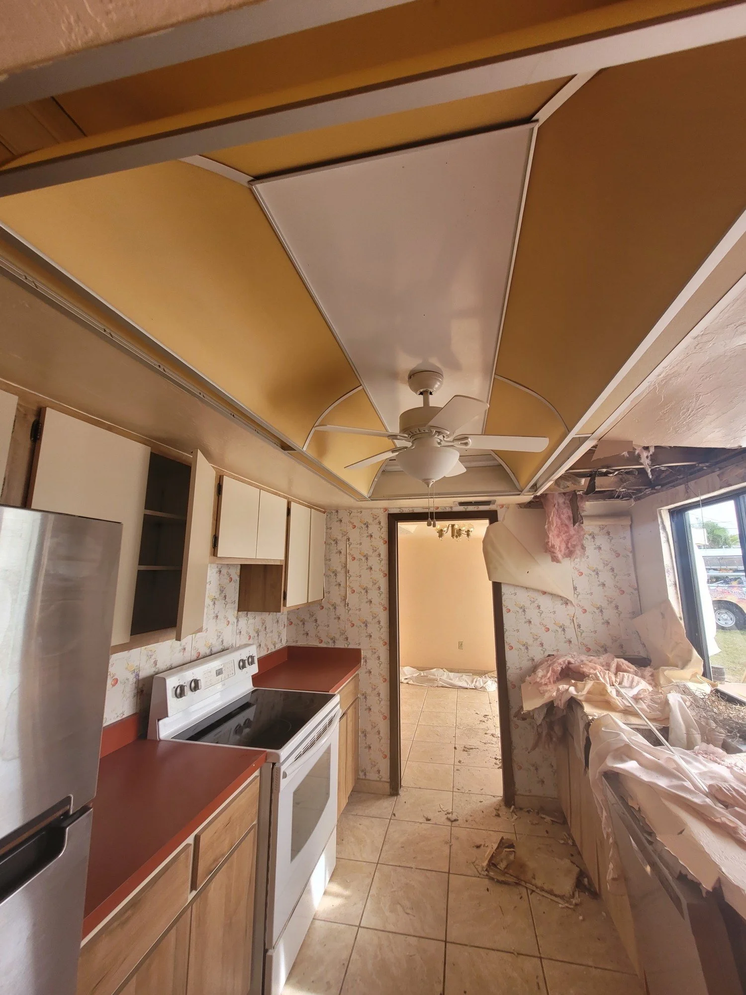 Storm-damaged kitchen before renovation, stripped to exposed walls and ceiling