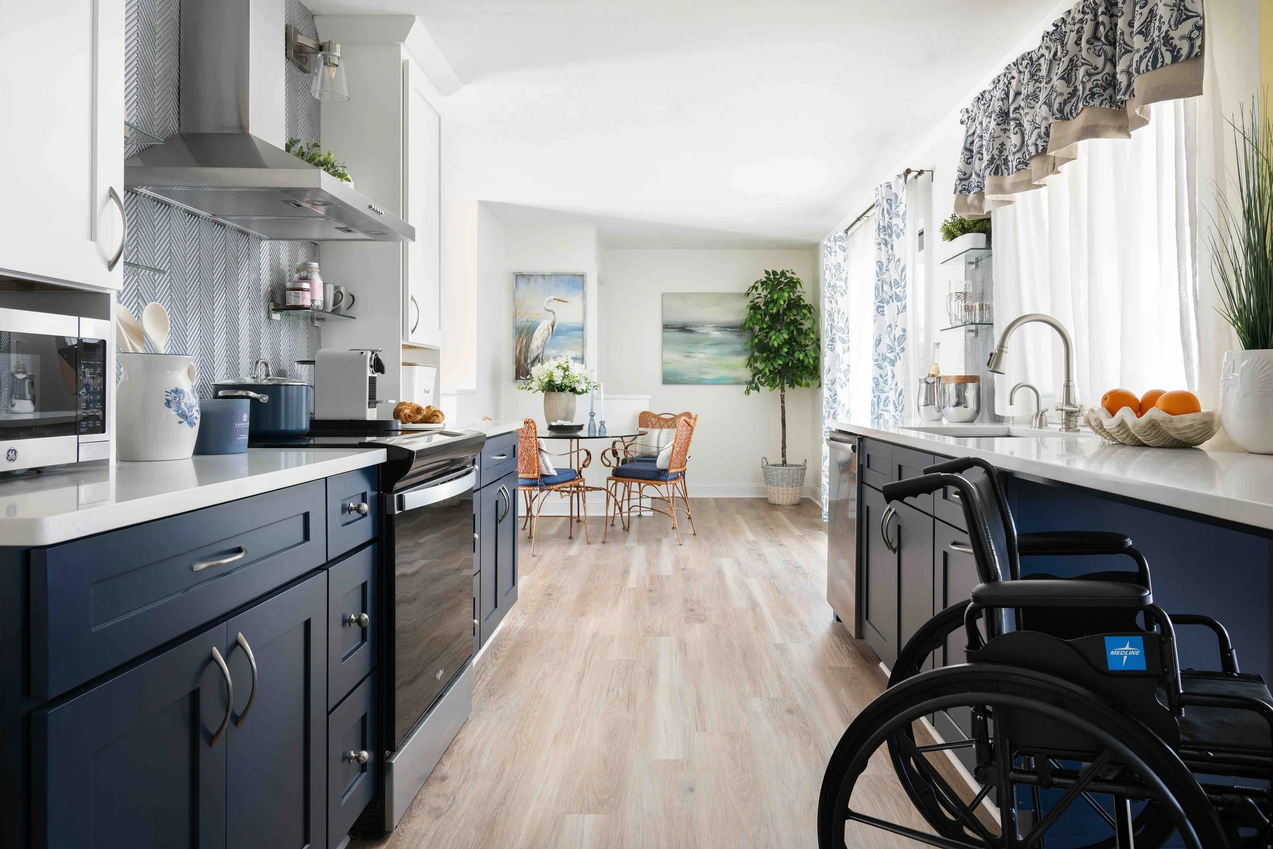 Renovated wheelchair-accessible kitchen with navy cabinetry, from the Storm to Sanctuary project by Rendezvous Design