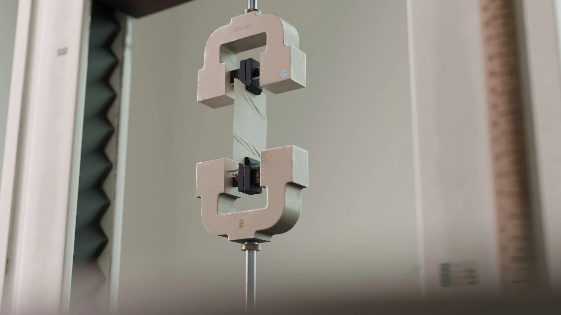 3D render of a fabric tensile strength machine stretching a piece of fabric.