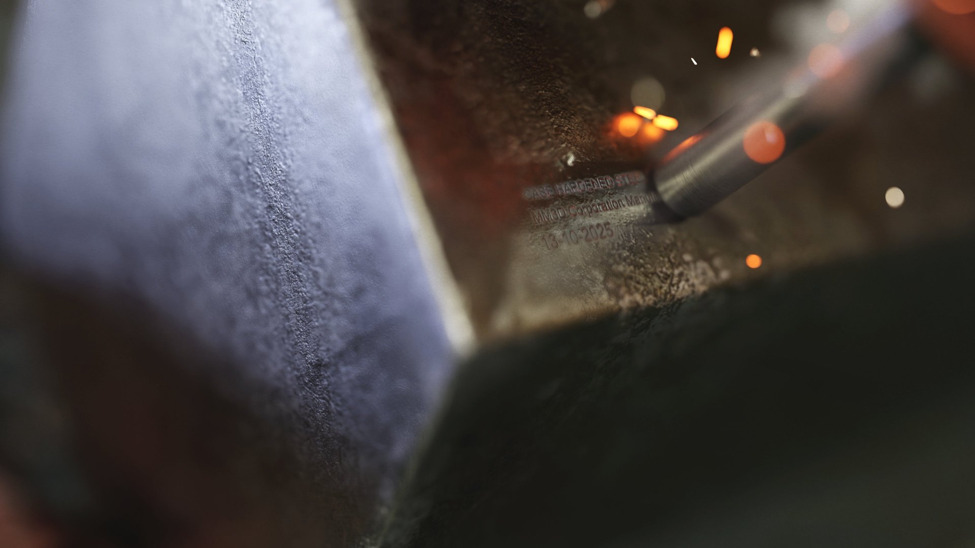 Extreme close-up 3D render of a metal rod having text engraved into it by a milling machine.