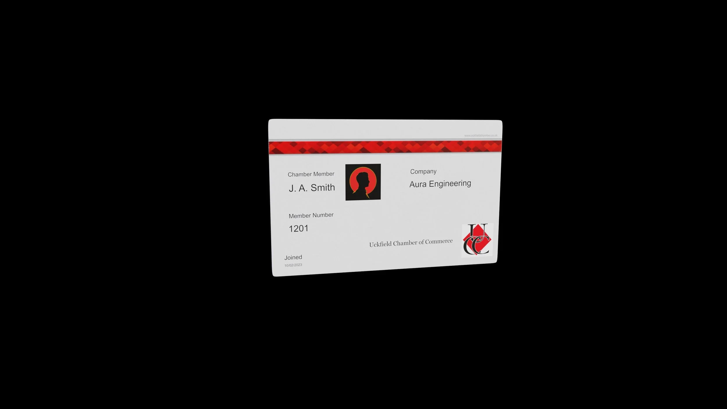 Identification card for J. A. Smith, a member of Aura Engineering at Uckfield Chamber of Commerce, with a red and black logo and a silhouette profile on a dark background.