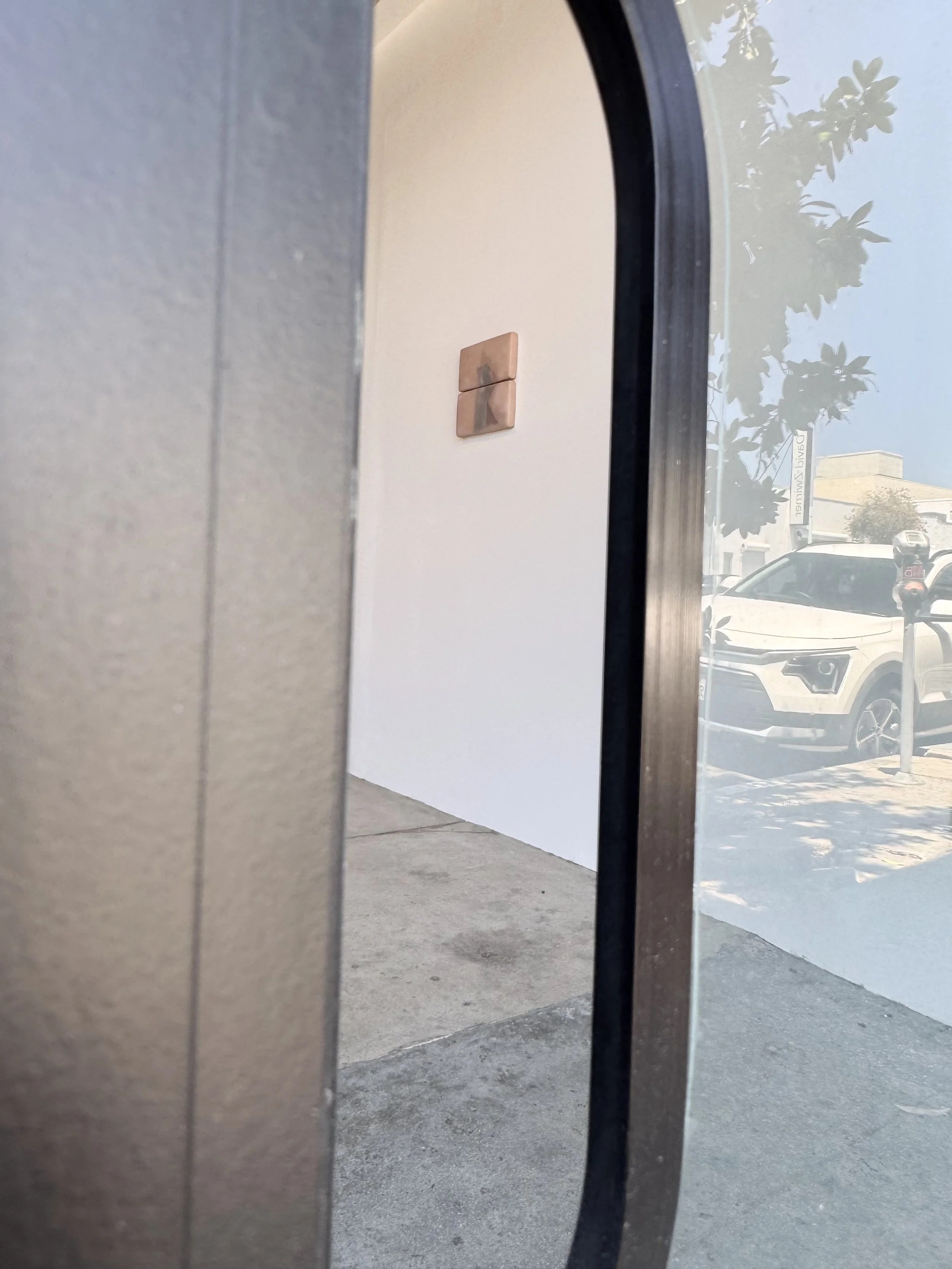[View into the gallery through Front-Door mailslot.] Visible: Matthew McGaughey. Hole Theory #4 . 2024. 