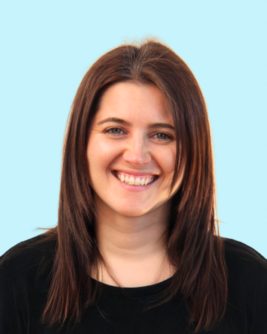 Smiling woman with brown hair wearing a black top, against a light blue background.