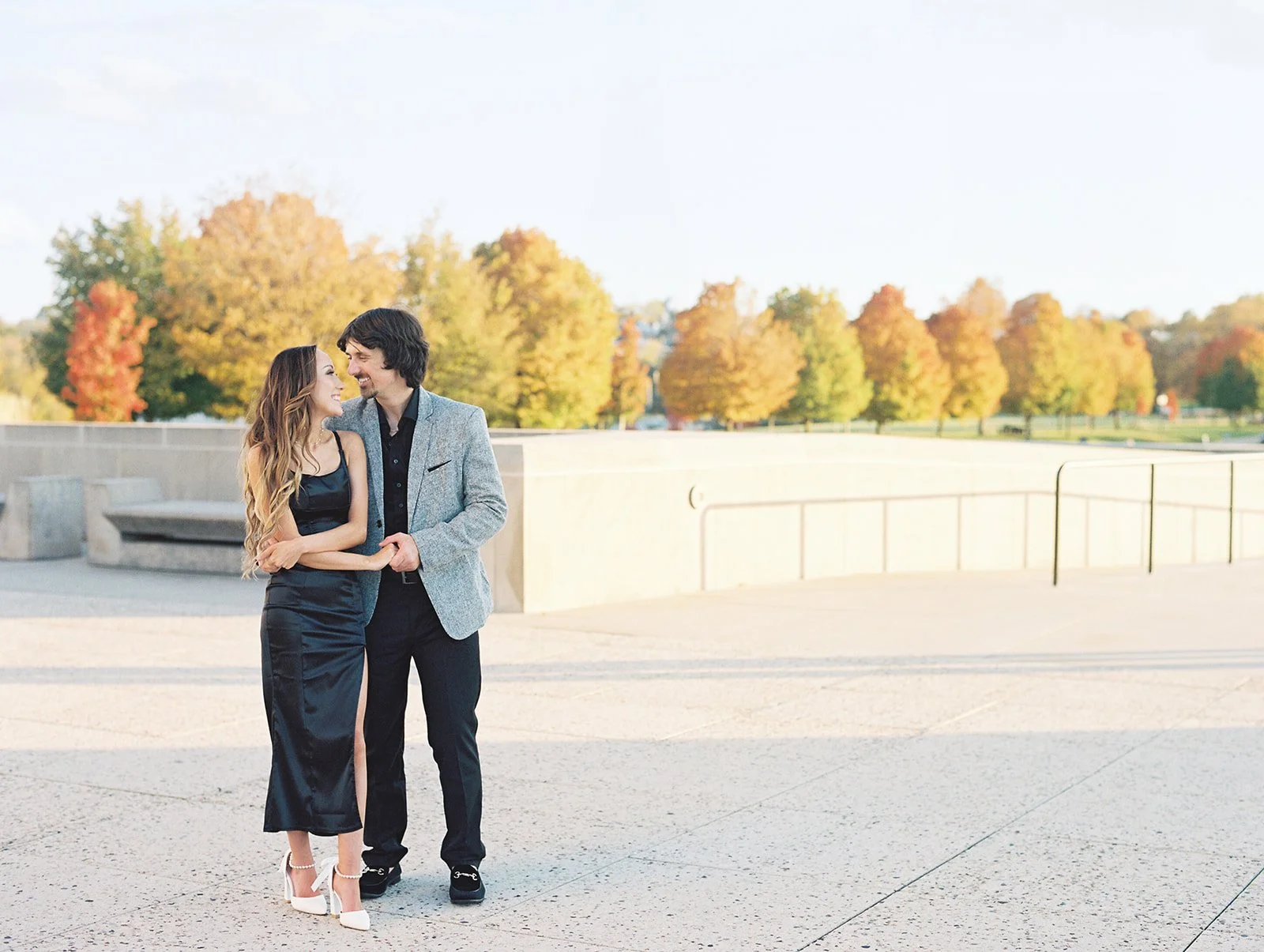 A male and female dancing at the Liberty Memorial Tower during their fall engagement session in Downtown Kansas City Missouri