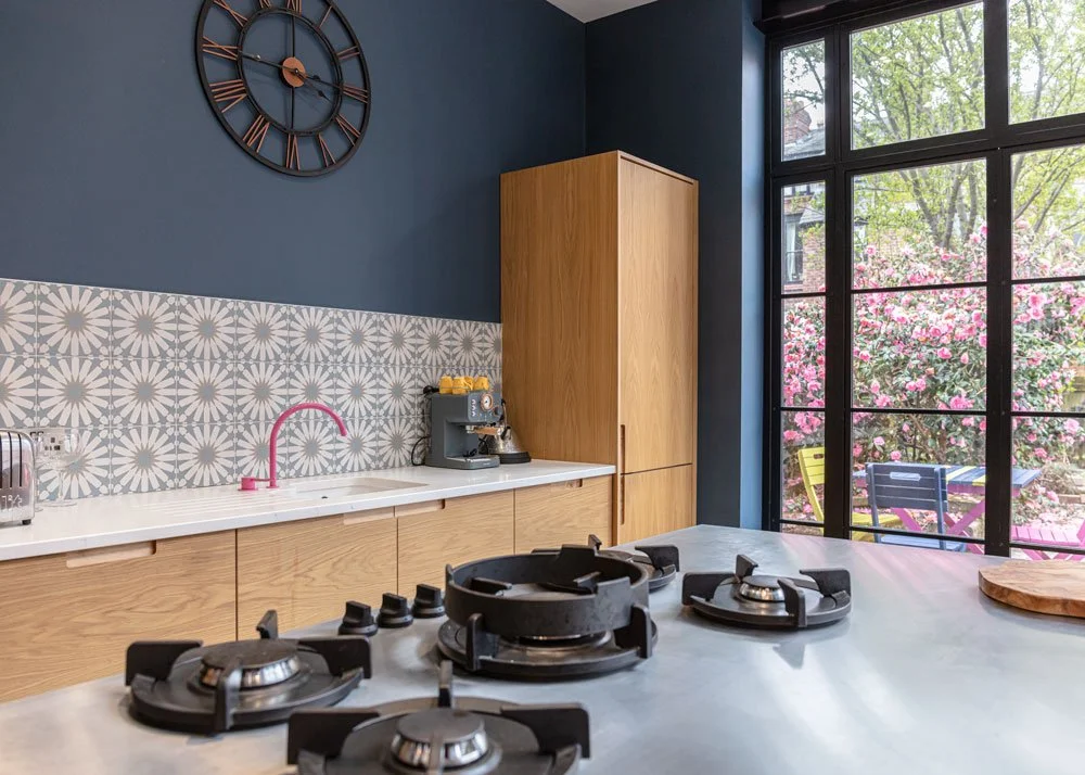 Close up of hob, with pink tap and patterned tiles, kitchen interior design, Manchester