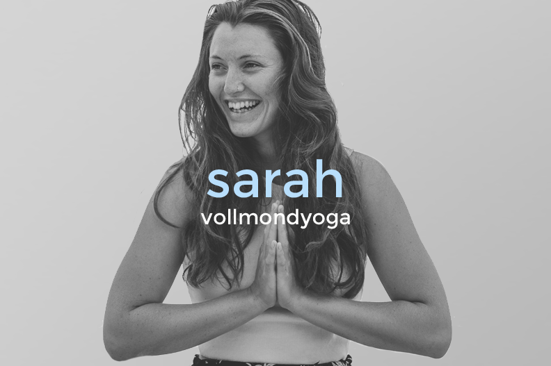 A smiling woman with long, wavy hair folding her hands in a prayer position in front of her chest, with text overlay that reads 'sarah vollmondyoga'.