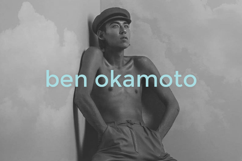 Black and white photograph of a shirtless man wearing a cap, standing against a wall with a cloudy sky background. The name 'ben okamoto' is overlaid in light blue text.