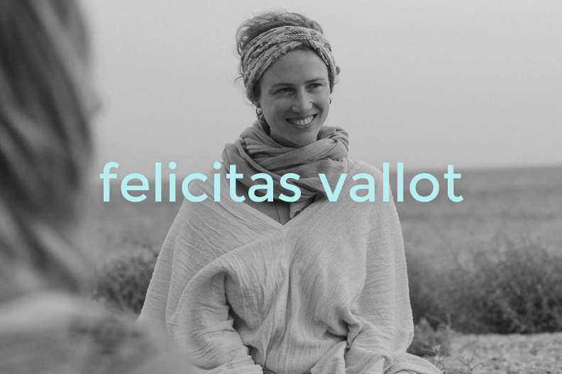 A woman smiling outdoors, wearing a headscarf and light clothing, with a grassy field in the background, overlaid with the text "felicitas vallot".