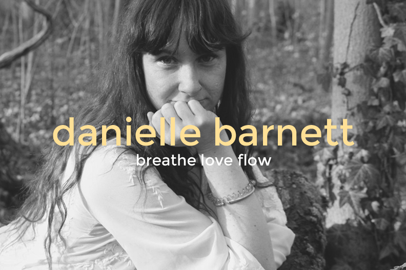 Black and white portrait of a woman with long hair, looking at the camera with her hand near her face, outdoors with trees and foliage in the background. Text overlay reads 'danielle barnett breathe love flow'.