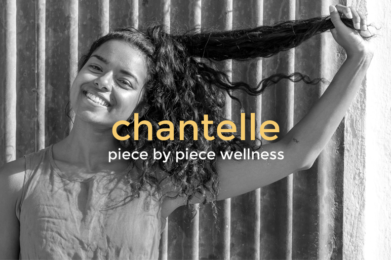 Smiling woman with curly hair holding a lock of hair against a striped background, with the text 'chantelle piece by piece wellness' overlayed.