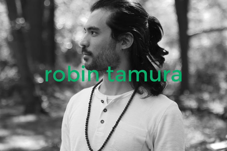 Black and white photo of a man with long, dark hair and a beard, wearing a white shirt with buttons and a beaded necklace, looking to the left in a forest setting, overlaid with green text reading 'robin tamura'.