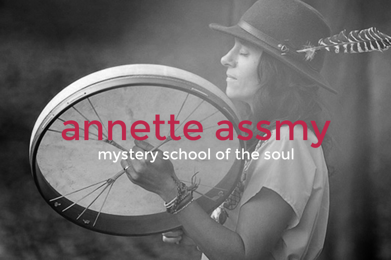 Black and white photo of a woman wearing a hat with a feather, holding a large drum and standing outdoors, with her eyes closed and a serene expression, overlaid with text: "annette assmy" and "mystery school of the soul."