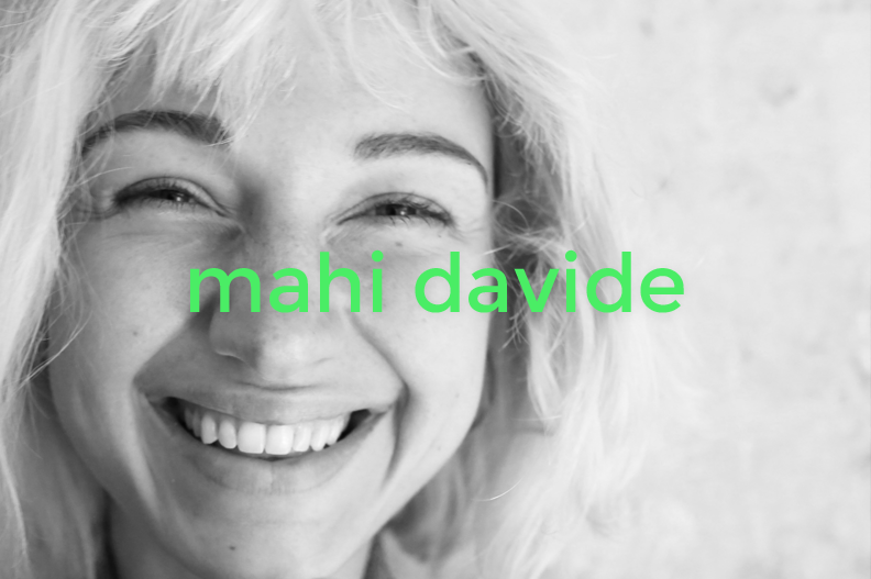Black and white photo of a smiling woman with wavy blonde hair, with the name 'mahi davide' in bright green text across the center.