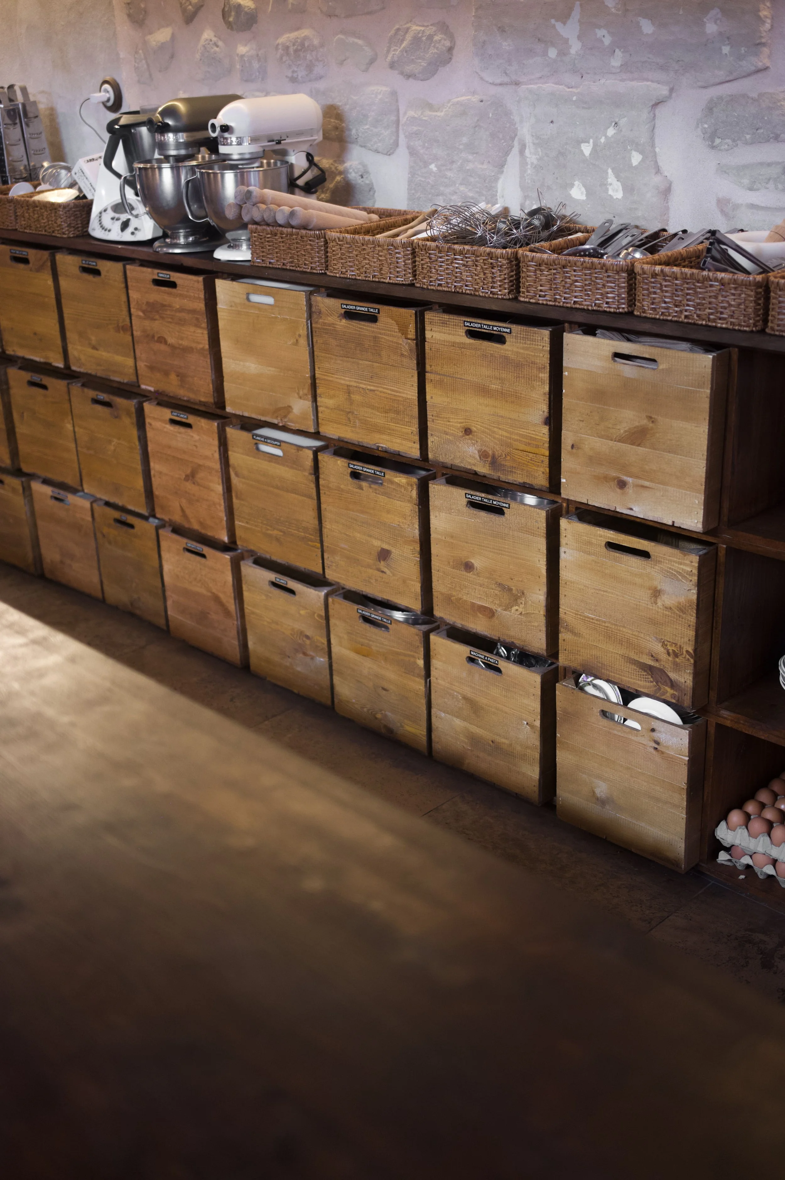 Wooden shelves containing jars and cooking utensils, a feature of a kitchen or restaurant.
