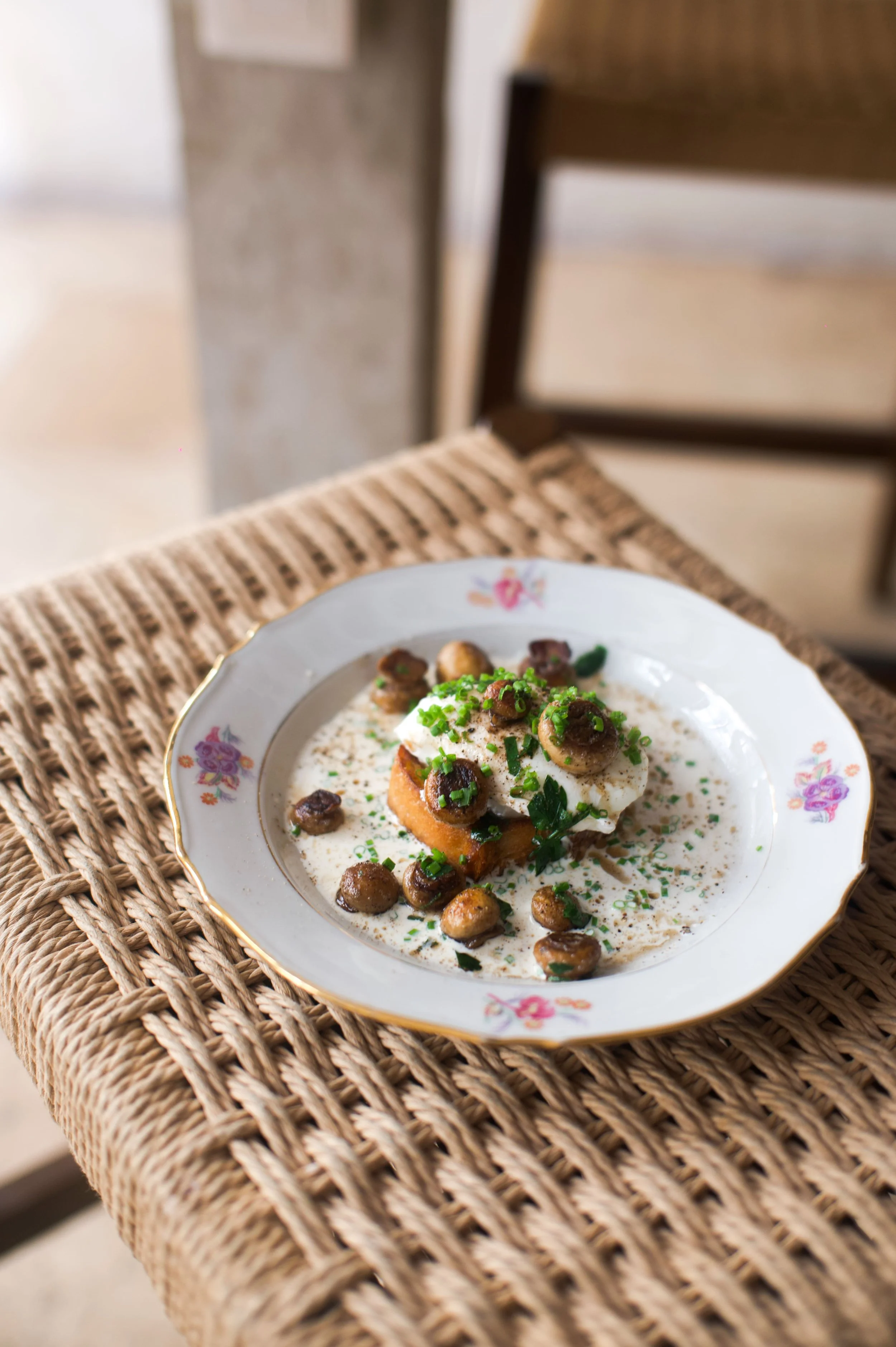 Assiette de nourriture avec œuf, champignons, herbes, sur une table en bois avec napperon en osier.