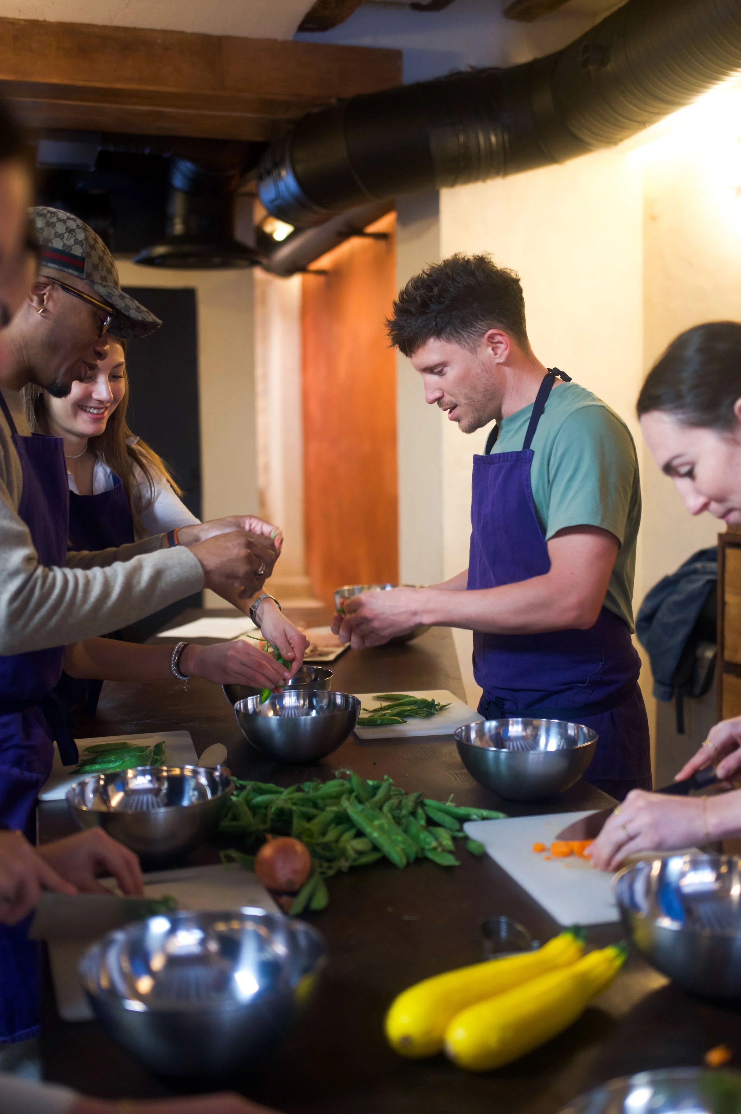Groupe de personnes préparant des légumes dans une cuisine.