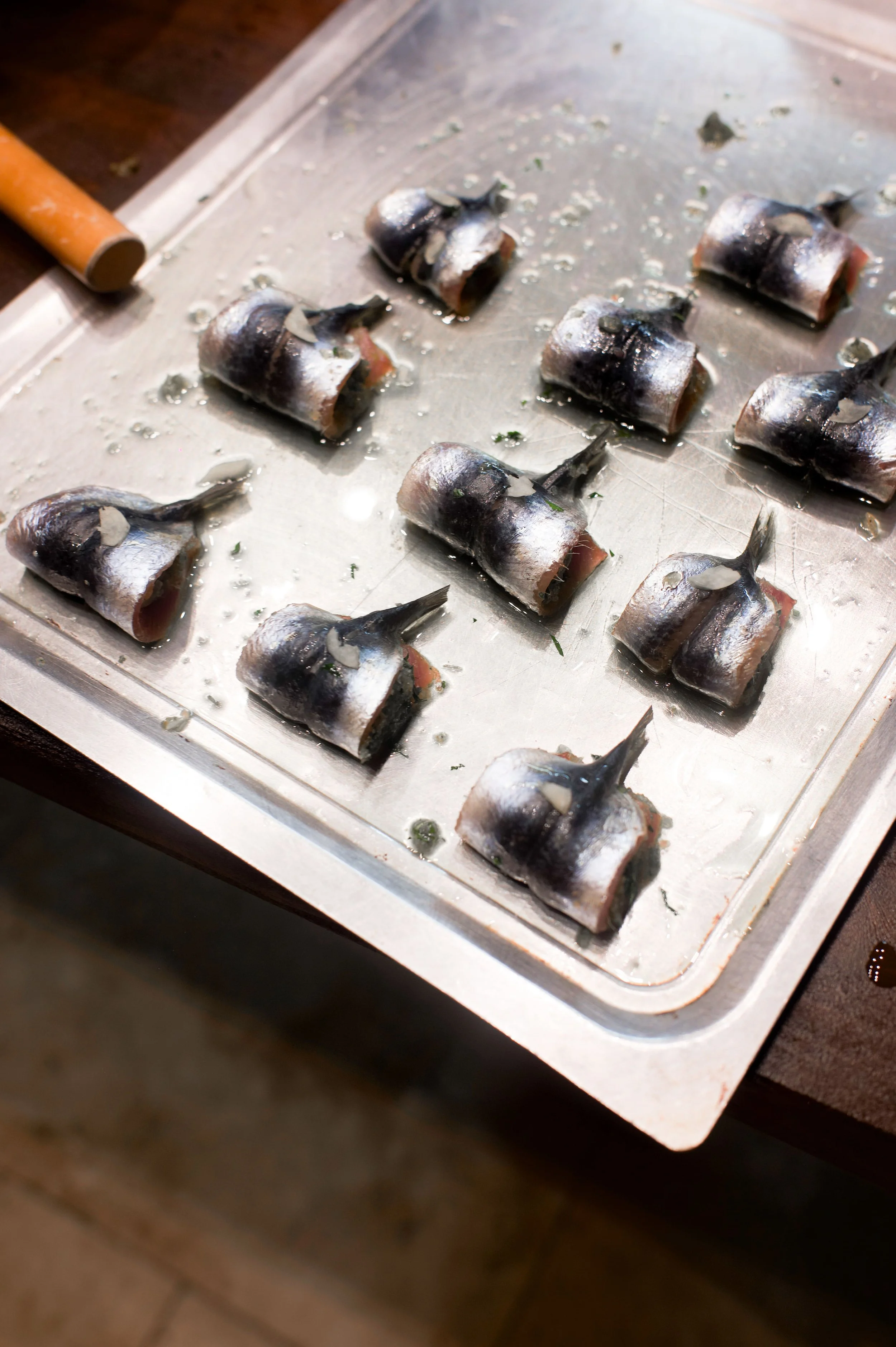 Filets de sardines sur une plaque de cuisson en acier inoxydable.