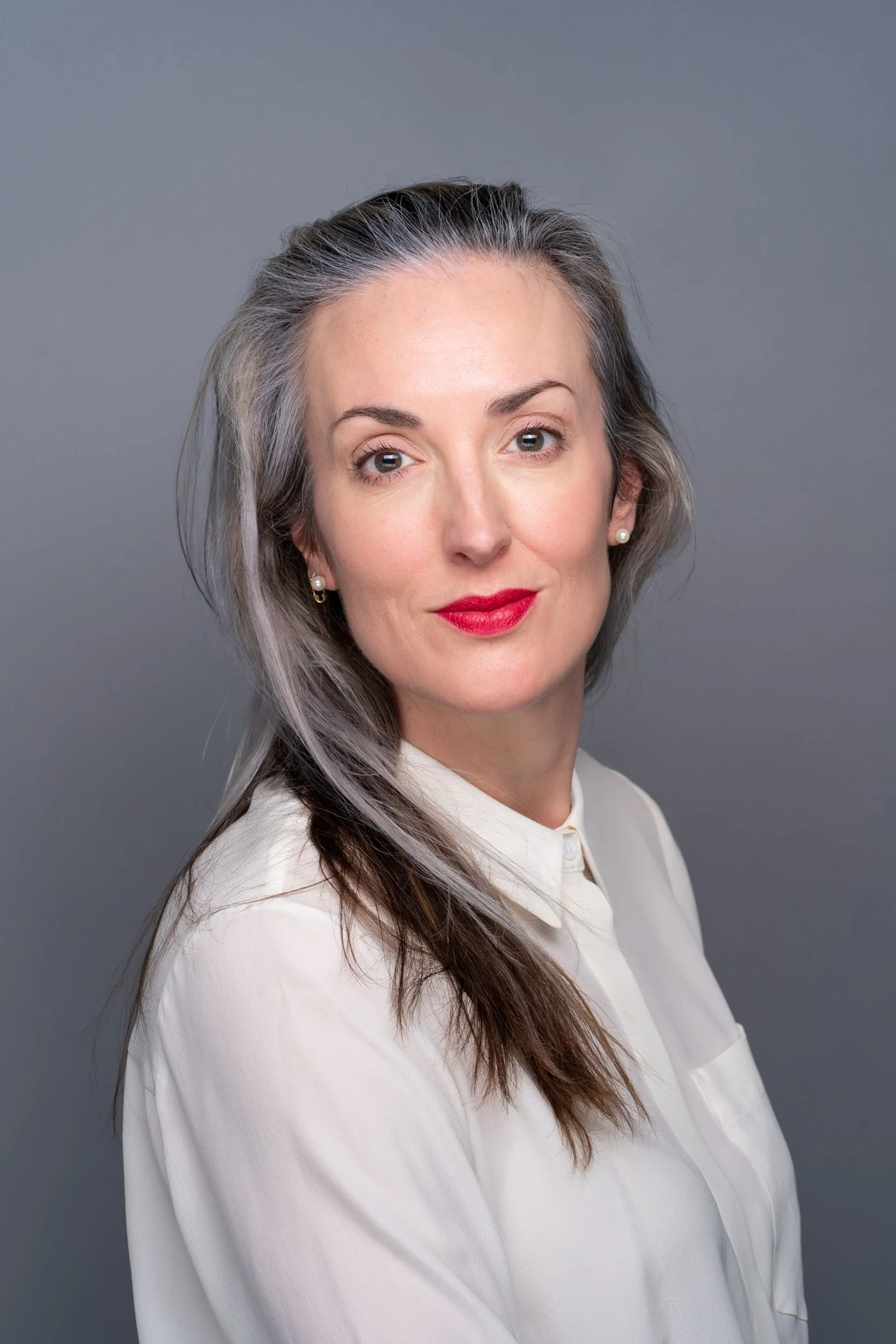Personal branding shoot in Leeds, a striking corporate portrait of a woman with long dark hair and red lipstick