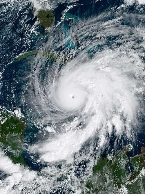 Satellite image of a large hurricane with a well-defined eye approaching land.