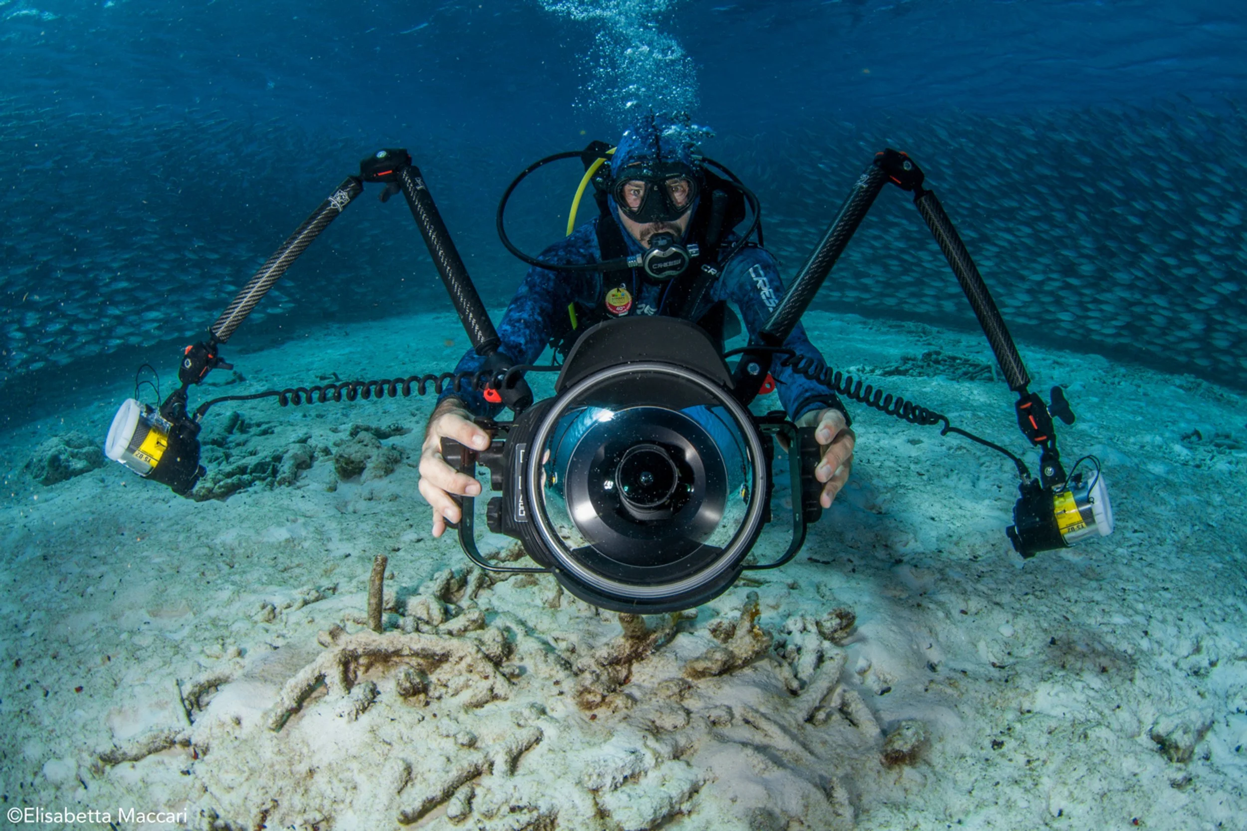Underwater diver operating a camera on a deep-sea ocean floor