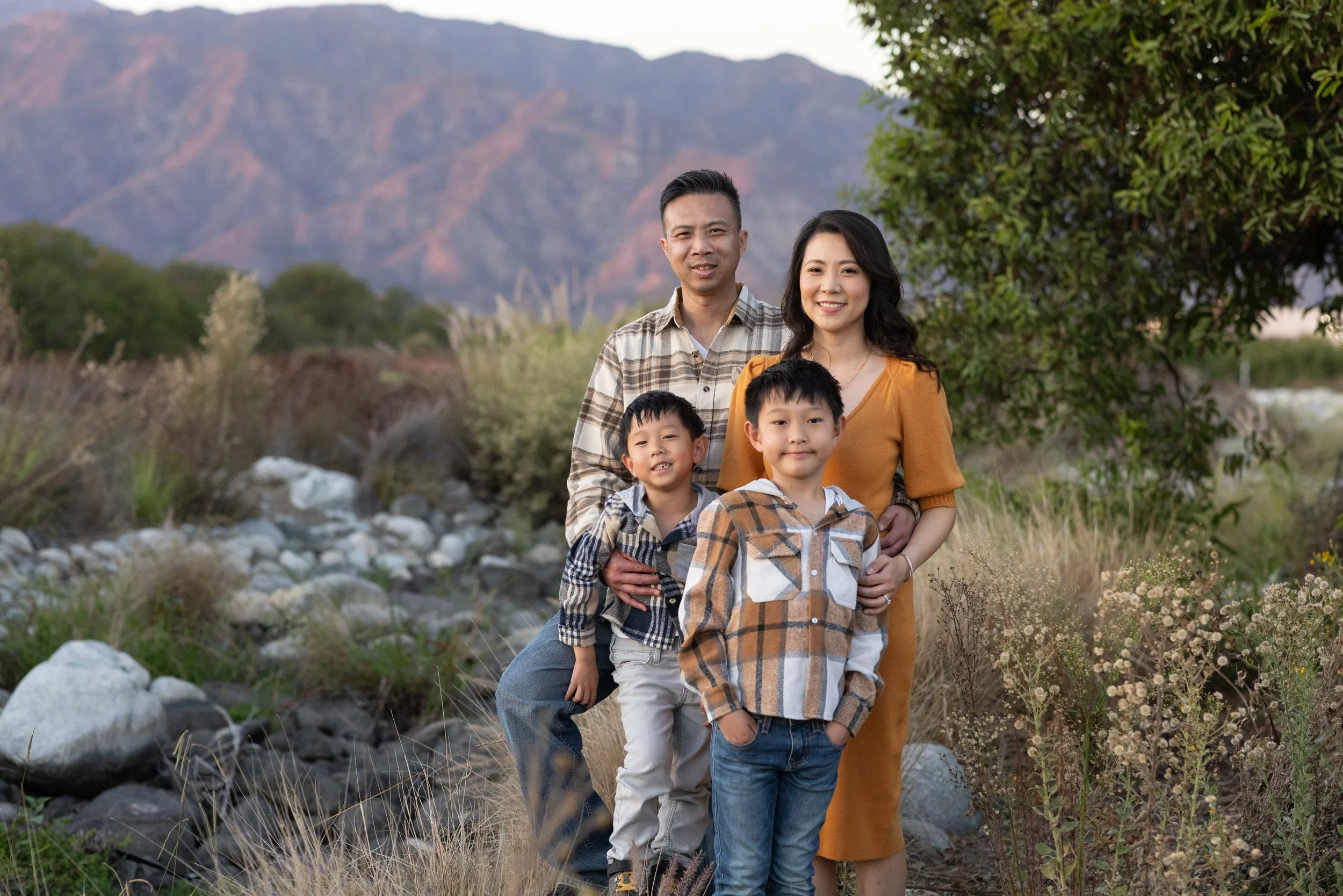 Family of four walking with a california sierra desert backdrop at sunset