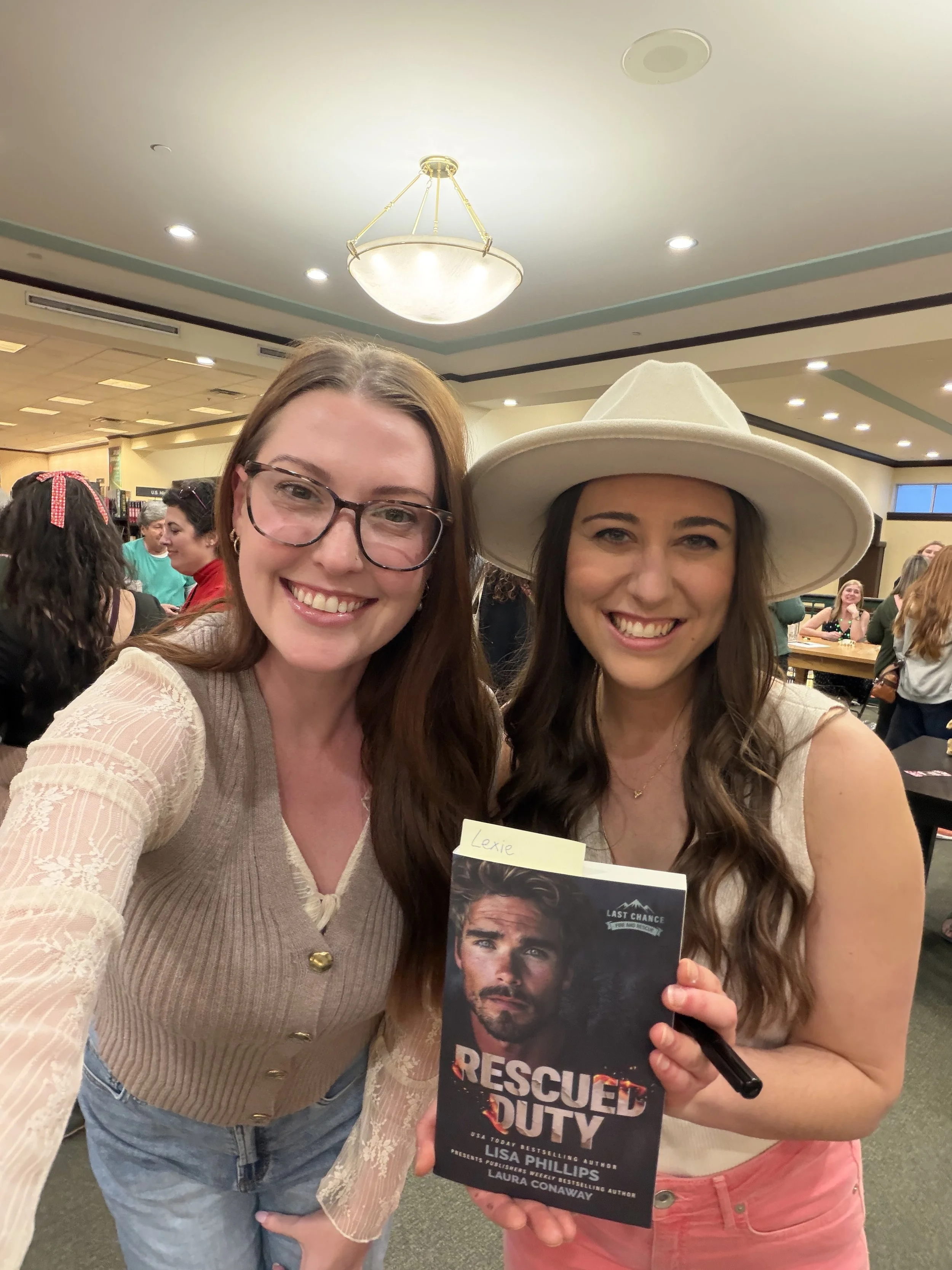 Author Laura Conaway taking a selfie with a reader at a book signing