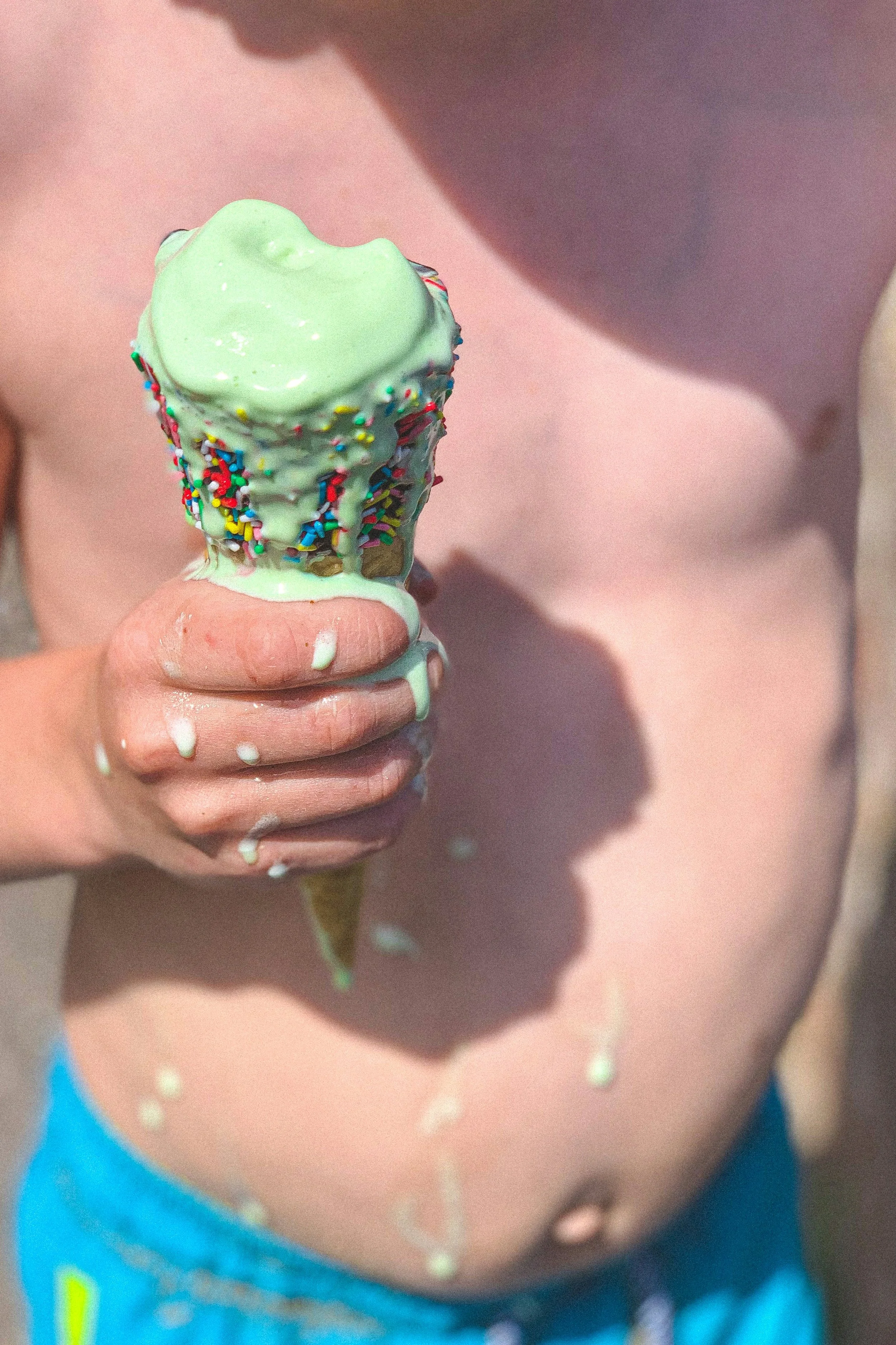 ice cream cone dripping onto person's hand