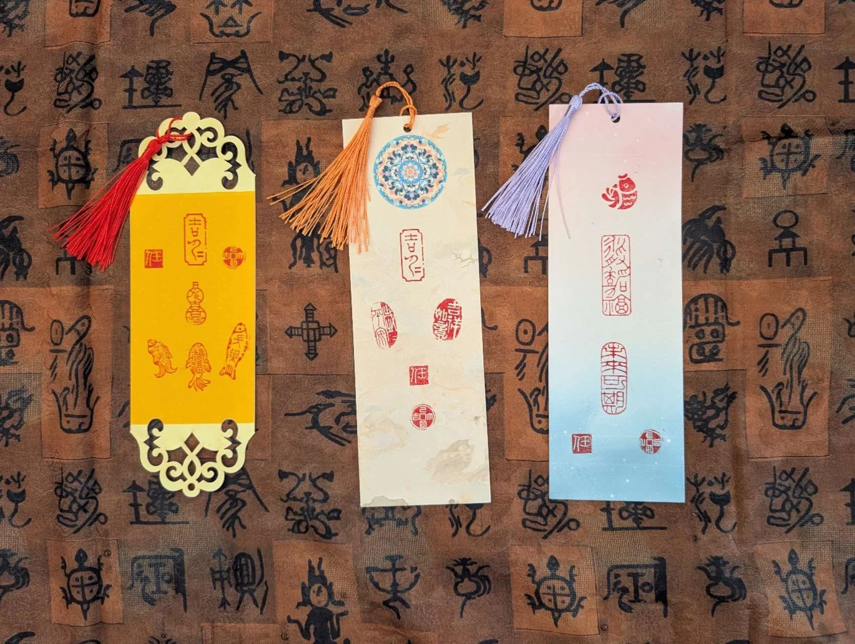 Three handmade bookmarks by Jingmin Ren 任静敏 featuring Chinese leisure seals associated with blessings and joy, 福喜.